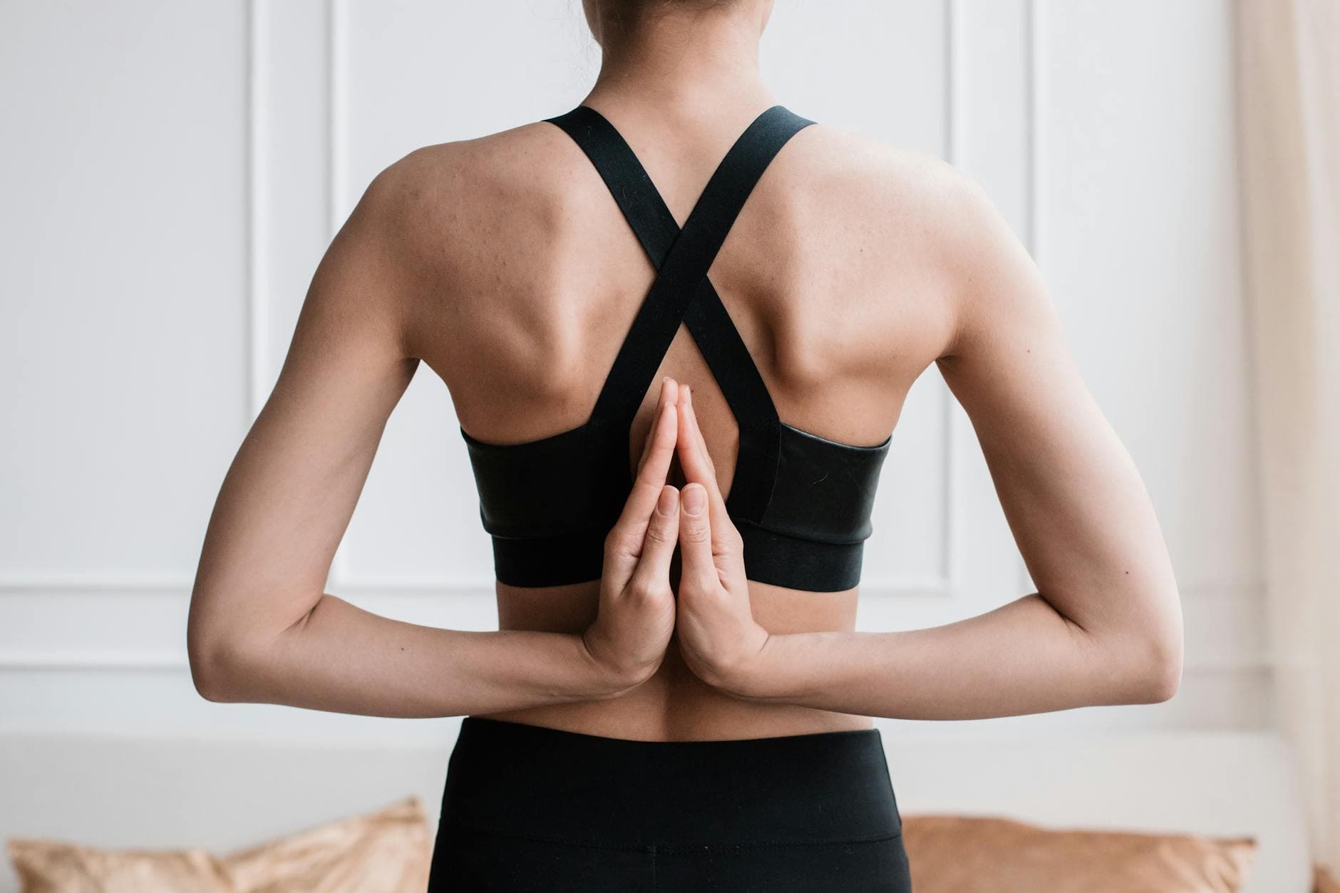 Close-up of a woman practicing the paschima namaskarasana yoga pose indoors. - upper back posture exercises