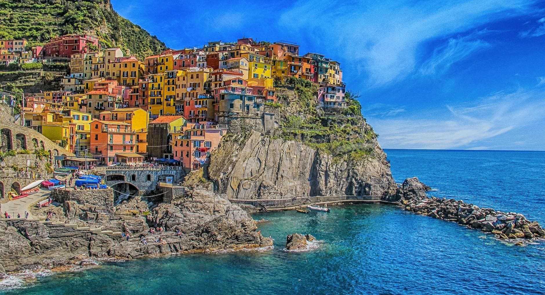 Vivid view of Manarola's colorful houses perched on cliffs, overlooking the blue sea. - best mediterranean cookbook