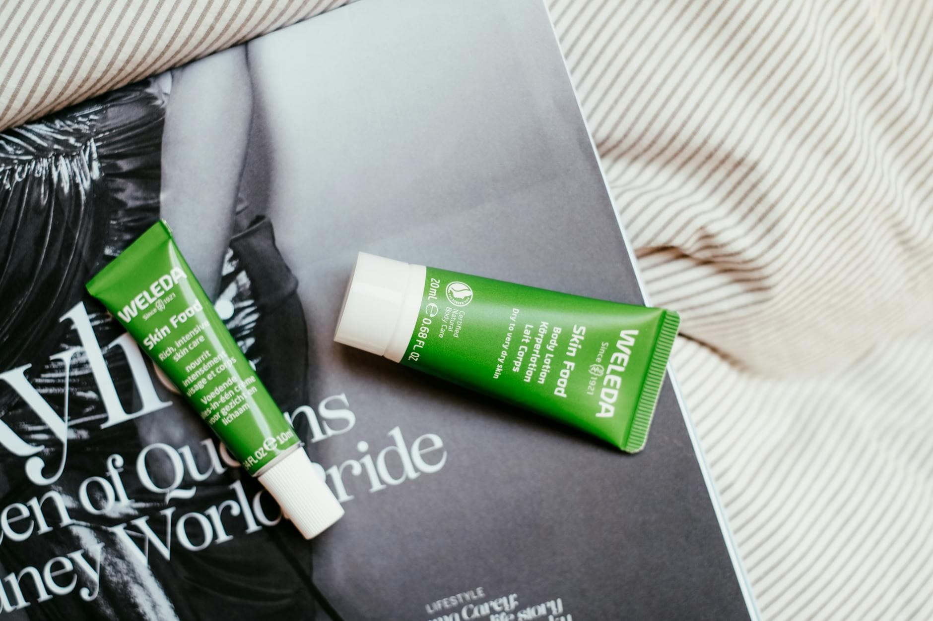 Two Weleda Skin Food tubes placed on a fashion magazine page. - best organic skincare