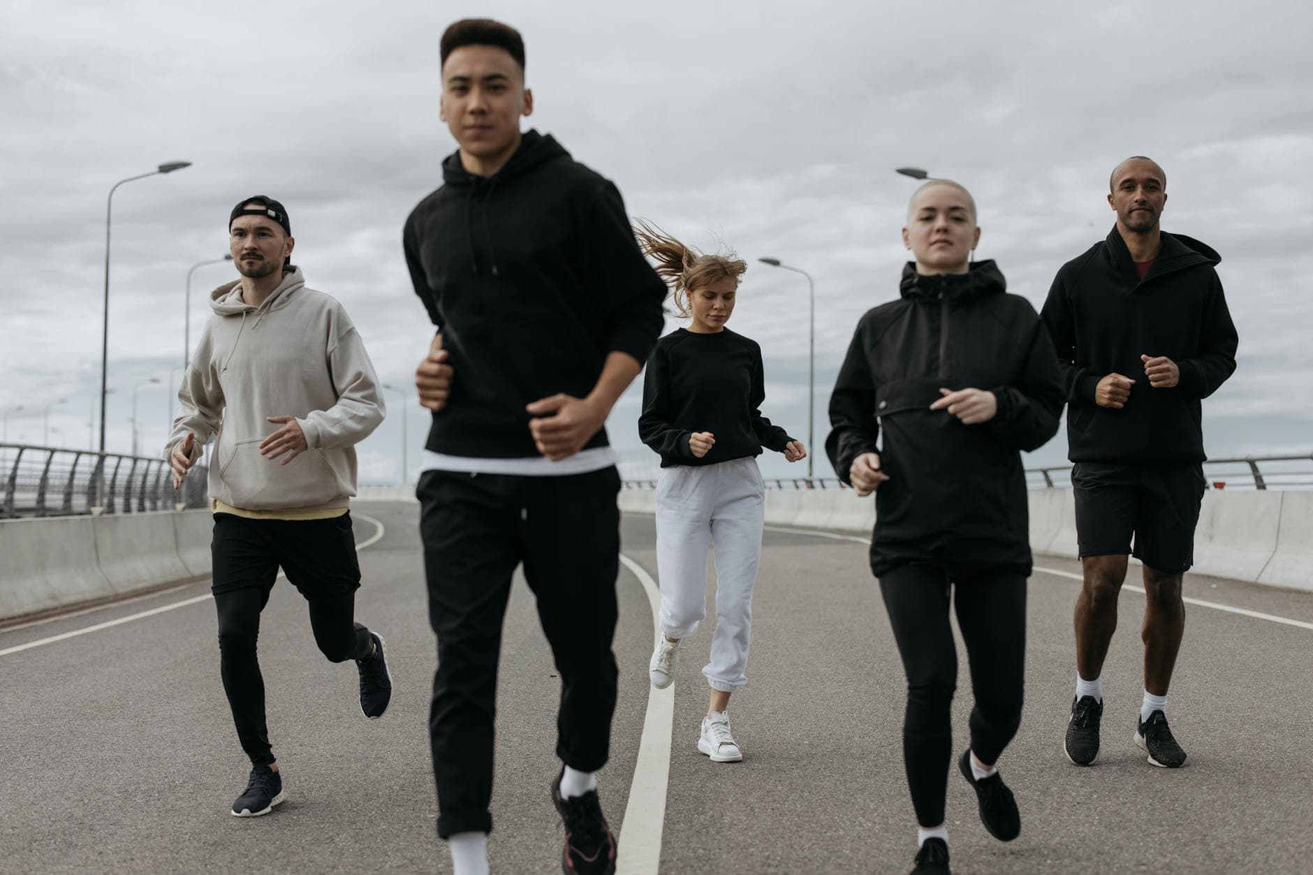 A diverse group of adults jogging together outdoors on a cloudy day. - cardio for women