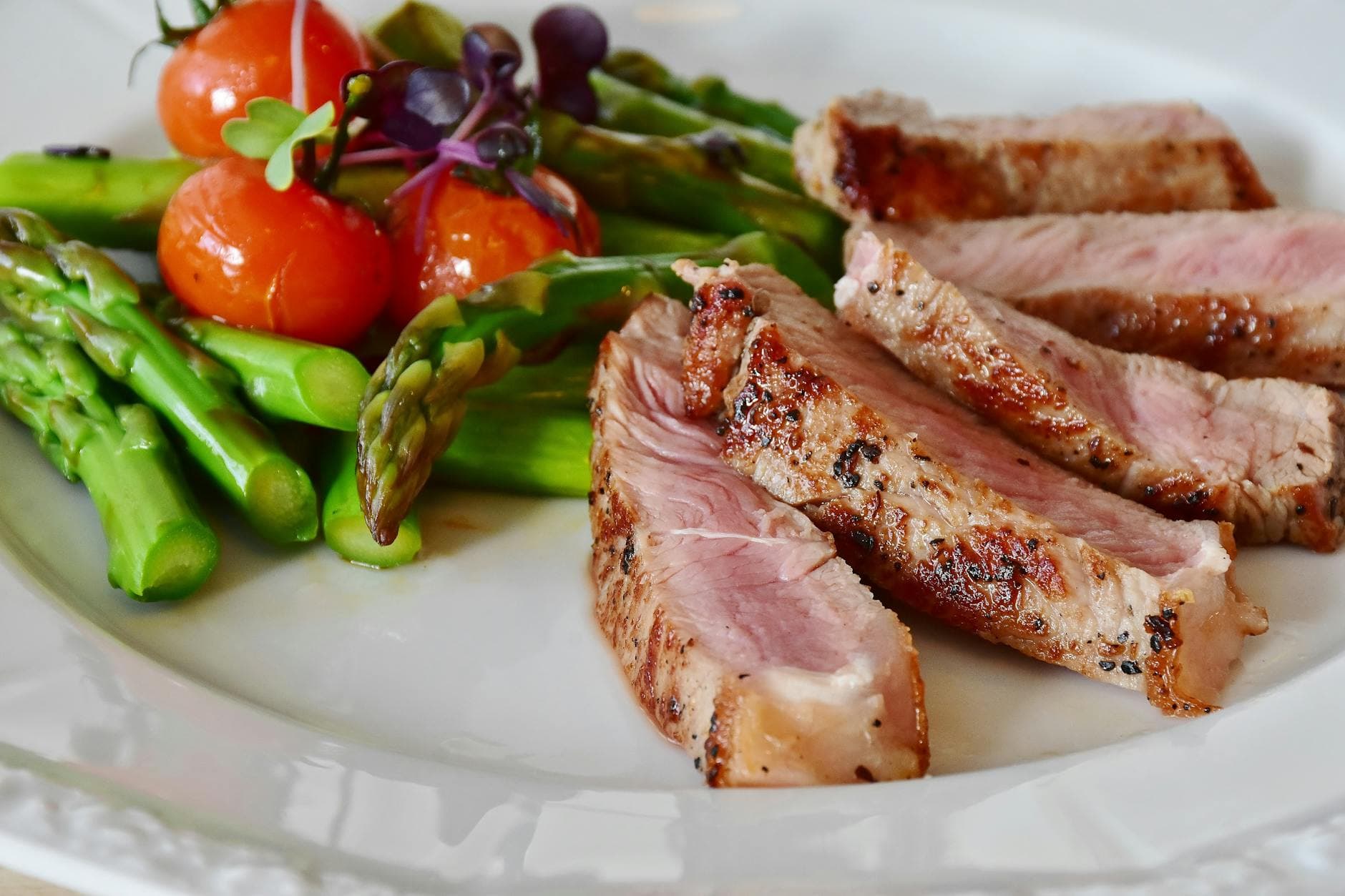 Close-up of grilled steak slices with asparagus and cherry tomatoes, perfect for a healthy meal. - easy healthy dinners