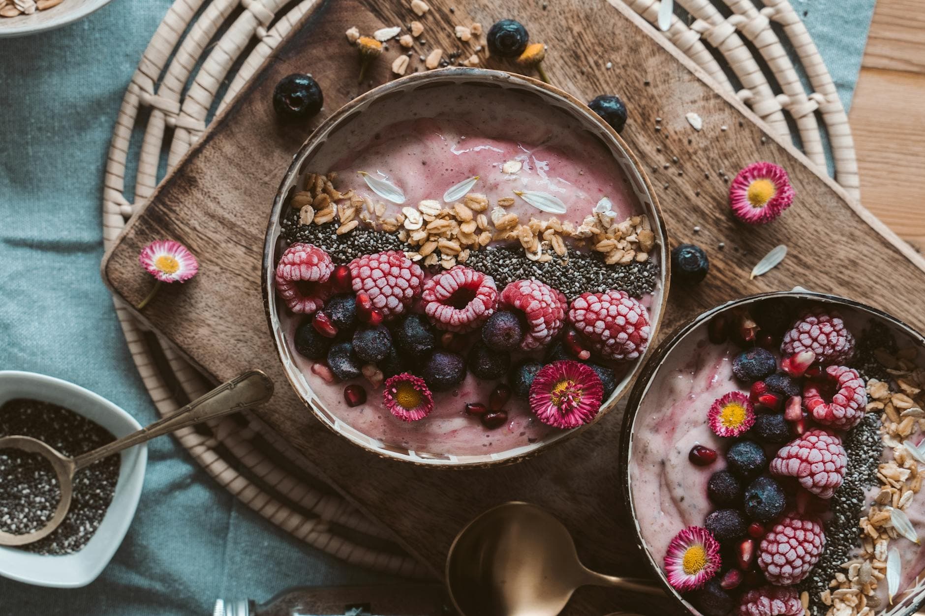 Delicious smoothie bowls topped with fresh berries, chia seeds, and granola on a rustic wooden table. - healthy smoothies