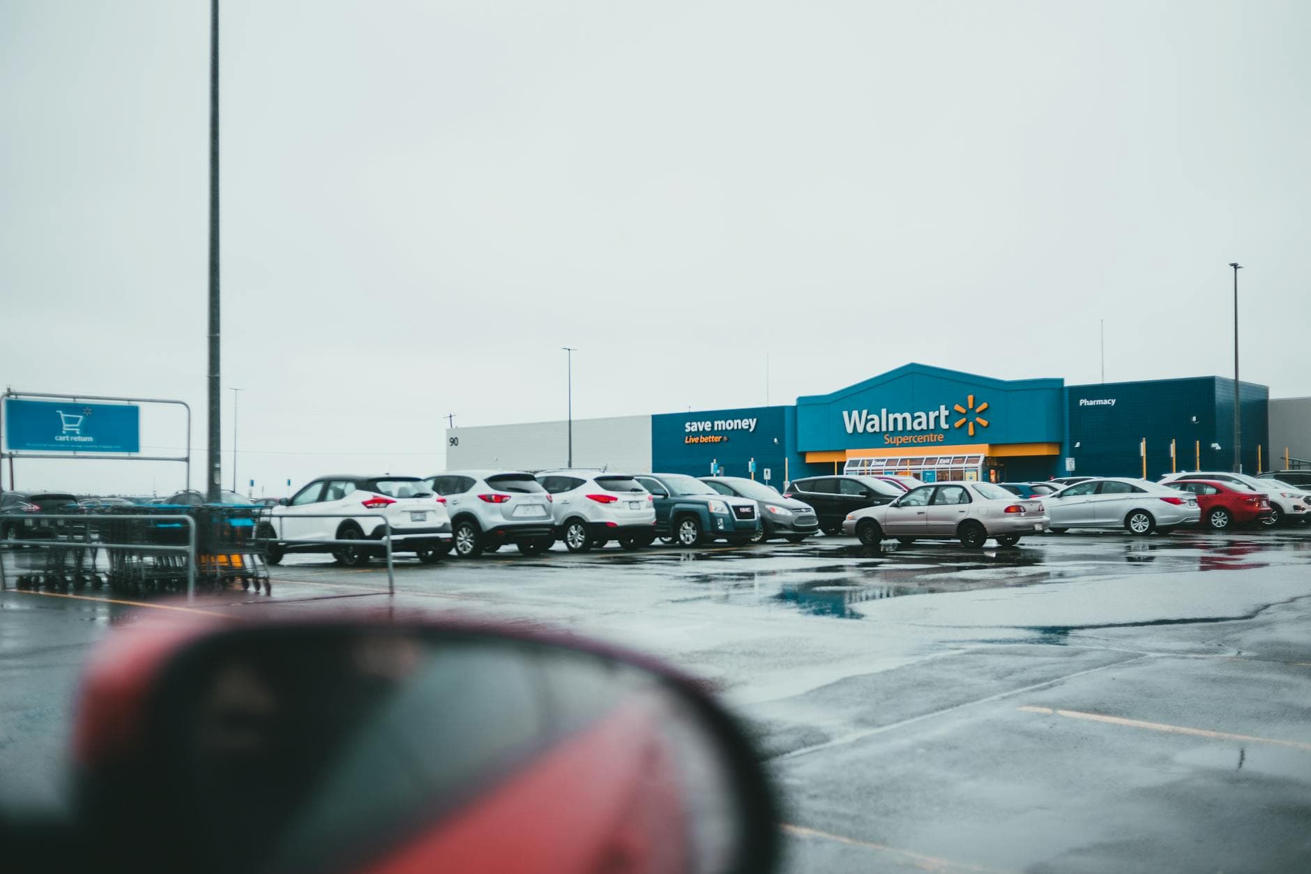 Red car with mirror parked near store in parking lot on street on autumn day - healthy snacks walmart