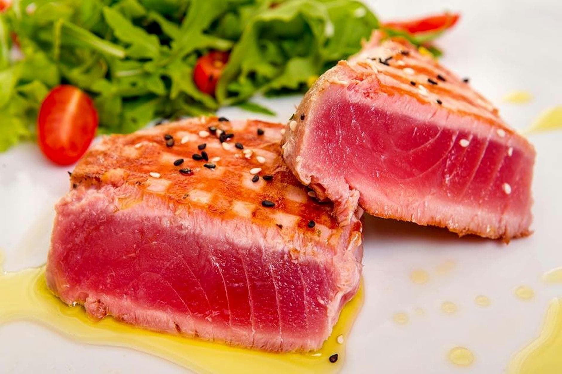 Close-up of succulent grilled tuna steak with fresh greens. - high protein low carb