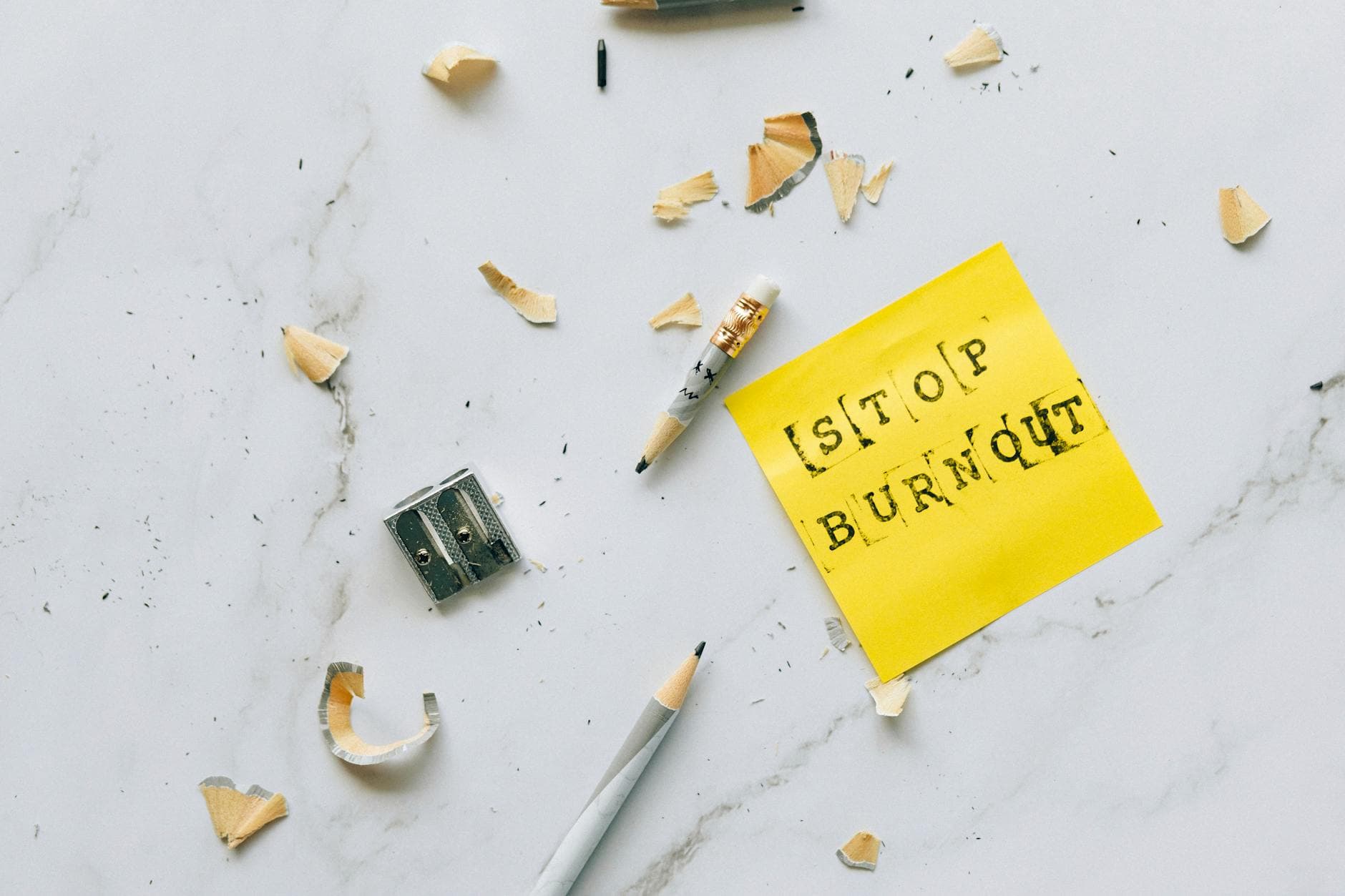 Pencil and shavings with 'Stop Burnout' note on marble surface convey stress relief concept. - spring mindfulness stress
