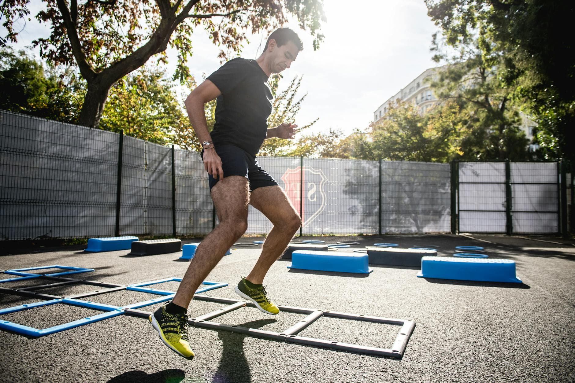 A man performing agility drills outdoors in a sunny park setting. - spring reset challenge