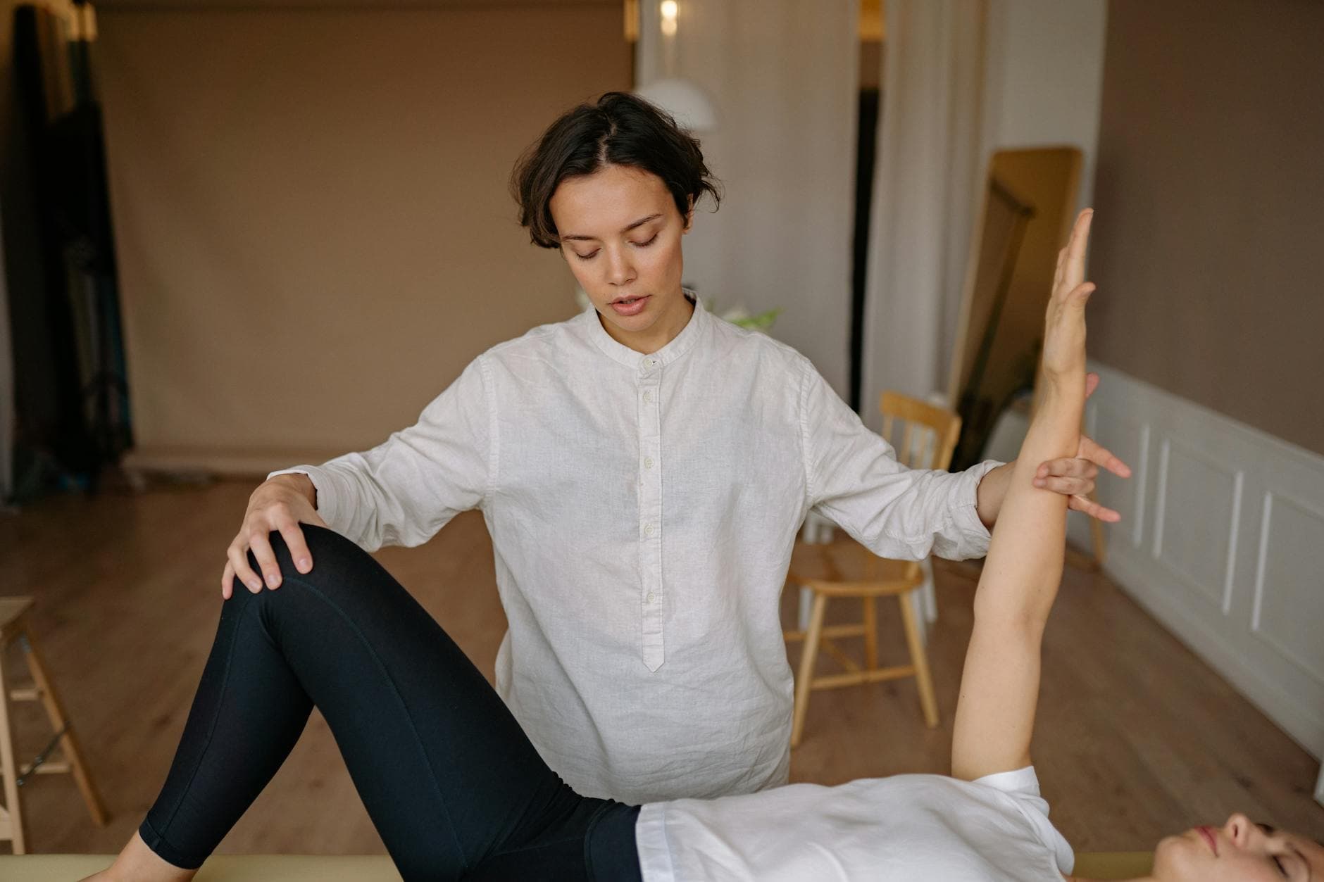 A chiropractor assists a patient during a therapy session indoors. - stress relief exercises
