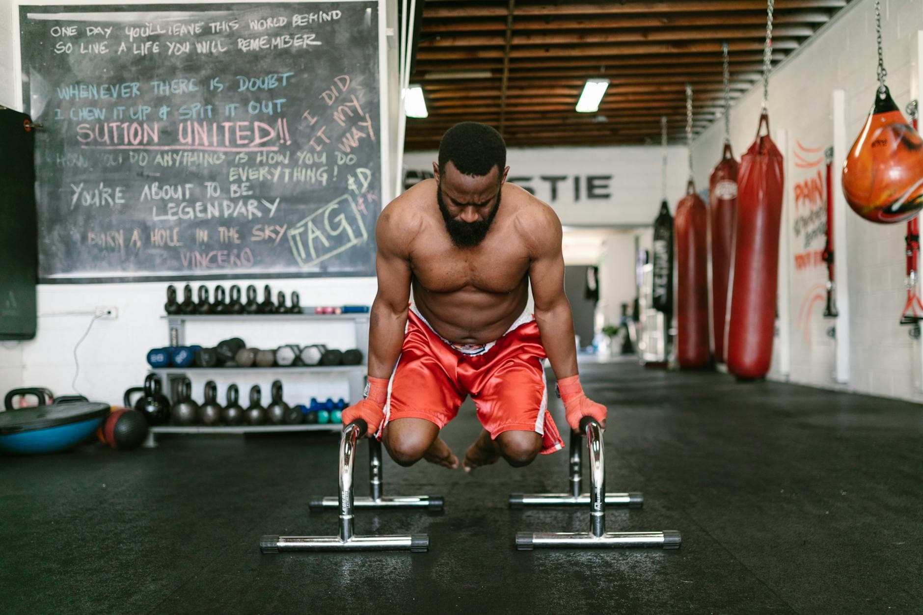 Muscular man engaged in a calisthenics workout indoors, showcasing strength and fitness. - bodyweight strength reset