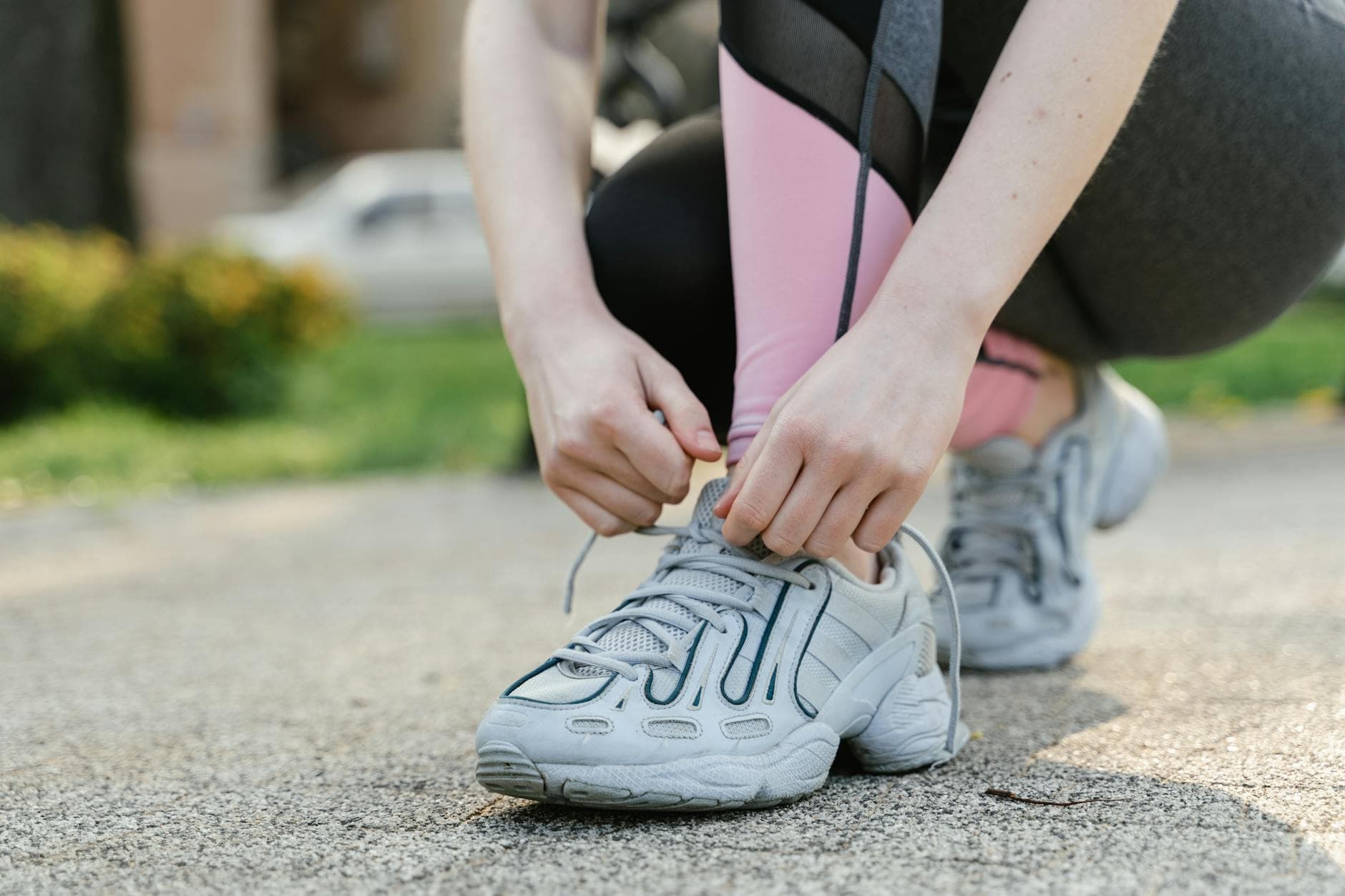 Woman tying shoelaces on sneakers before a run in the park. - couch to 5k spring