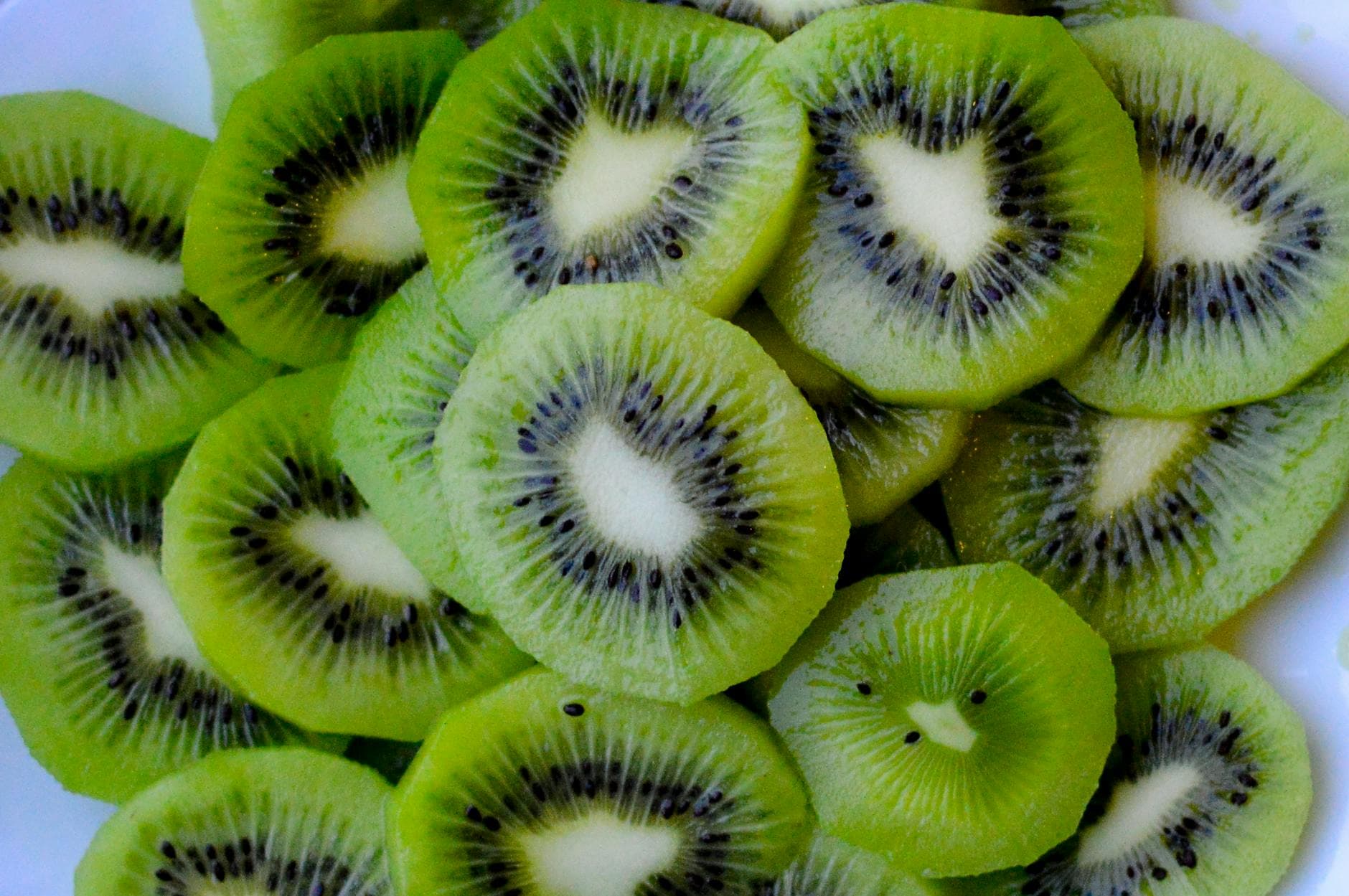 Close-up of fresh, vibrant green kiwi slices, showcasing texture and color. - raw food nutrition