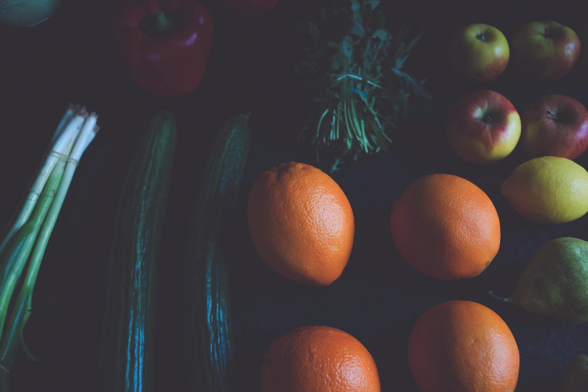 A colorful assortment of fresh fruits and vegetables on a dark surface, showcasing natural variety. - seasonal produce spring