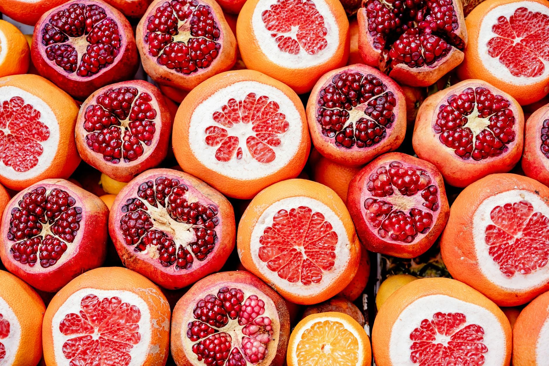 Bright and colorful arrangement of pomegranates and grapefruits showcasing freshness. - spring superfoods skin