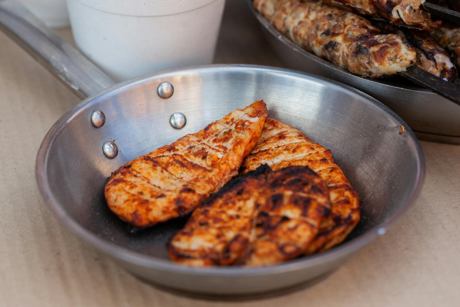 Delicious seasoned chicken breasts grilled and served in a stainless steel pan. - easy chicken recipes