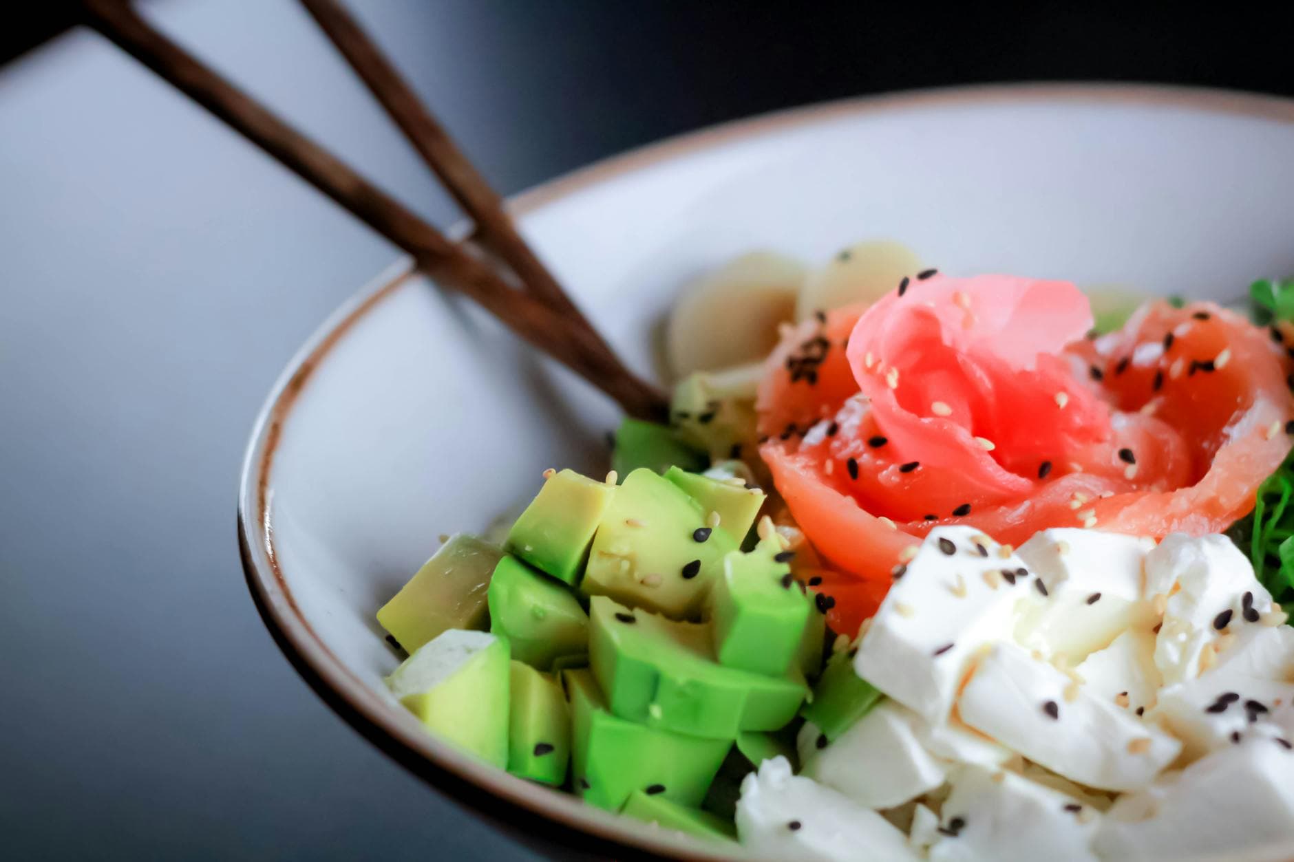 Close-up of a nutritious bowl with salmon, avocado, feta, and greens—perfect for healthy eating inspiration. - low fat low carb