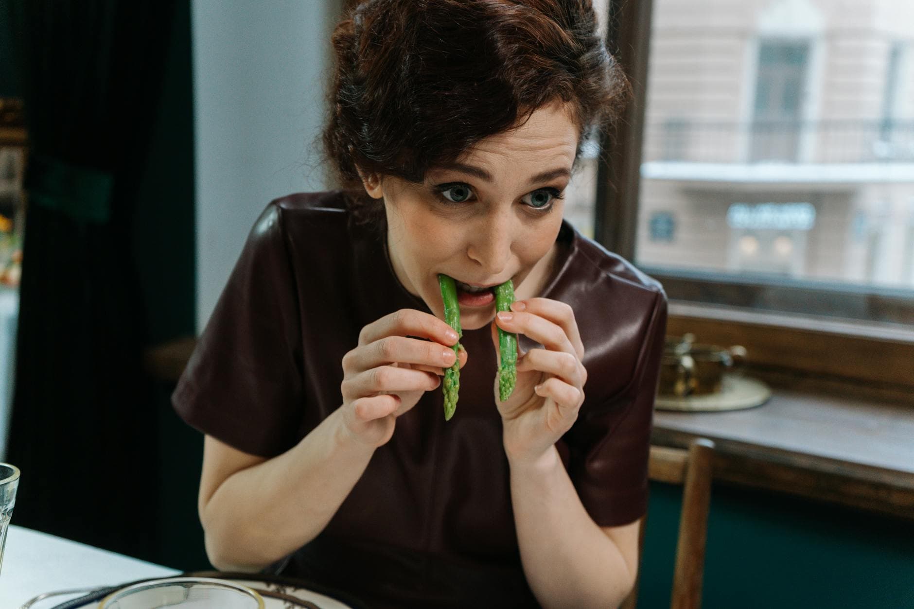 Woman dining on fresh asparagus indoors, embracing healthy eating habits. - mindful eating may