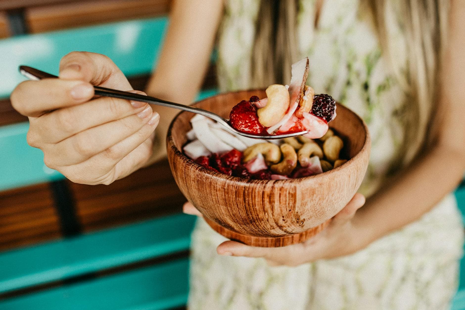 Healthy acai smoothie bowl with fresh berries and nuts held in a wooden bowl. - spring superfoods energy