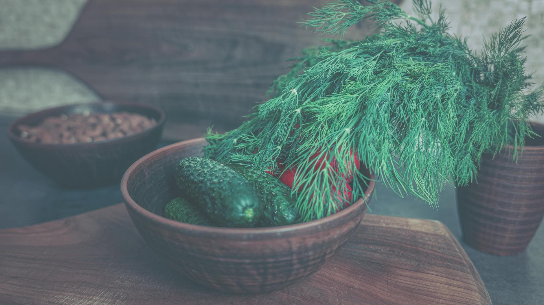 Fresh cucumbers and dill in a rustic wooden bowl, perfect for a healthy meal. - spring veggie bowls