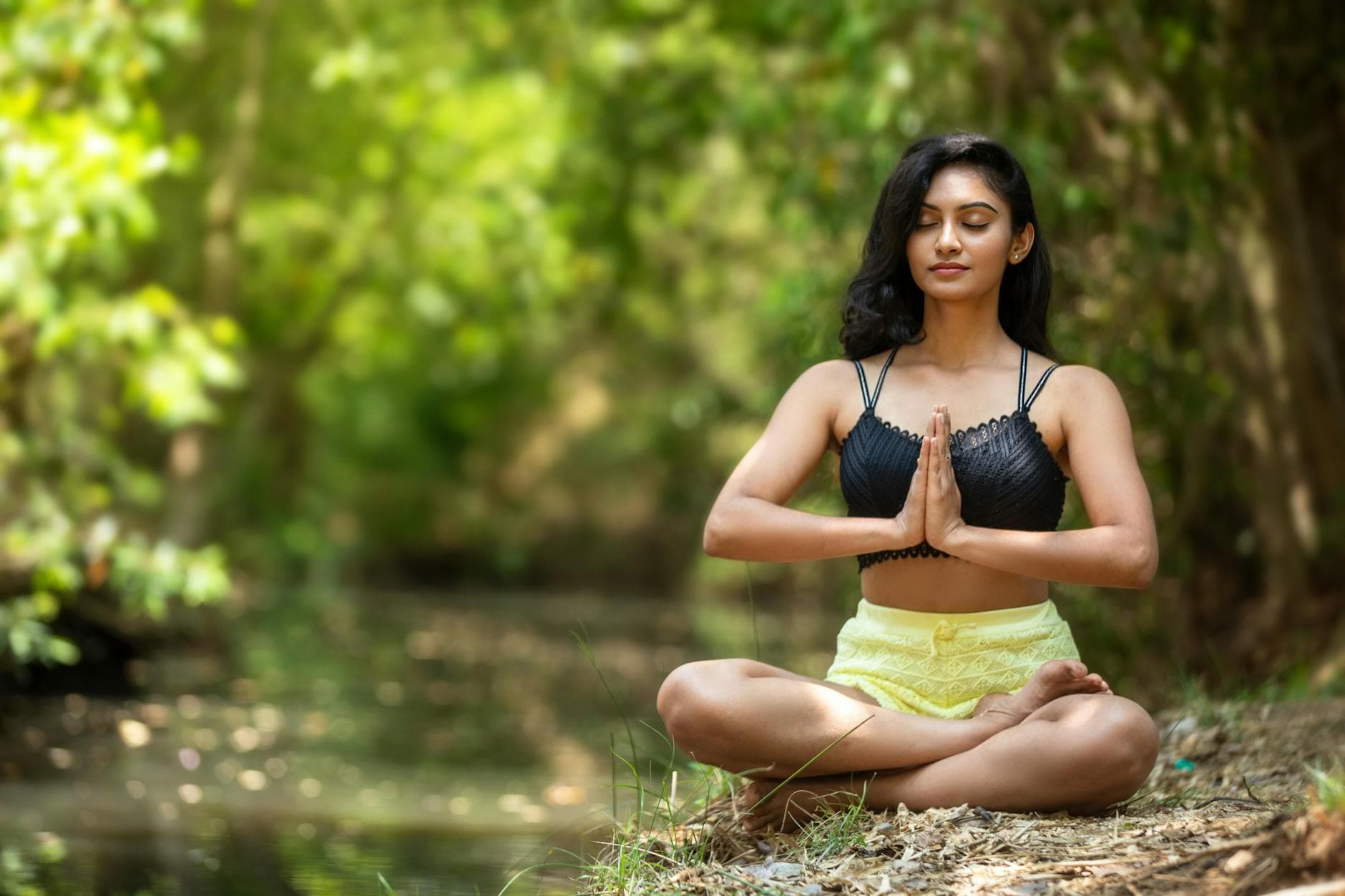 Woman practicing yoga outdoors by a serene water body, embodying peace and mindfulness. - beginner yoga poses