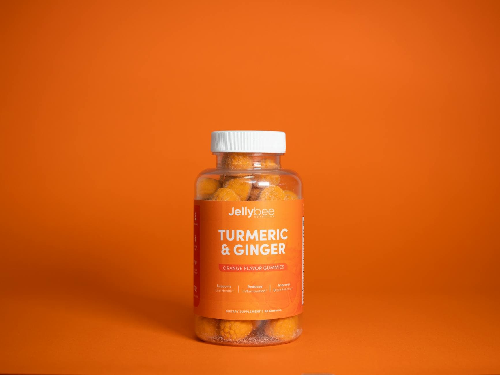 Bright image of Jellybee Turmeric & Ginger gummies in a plastic bottle against an orange backdrop. - foods that cause inflammation