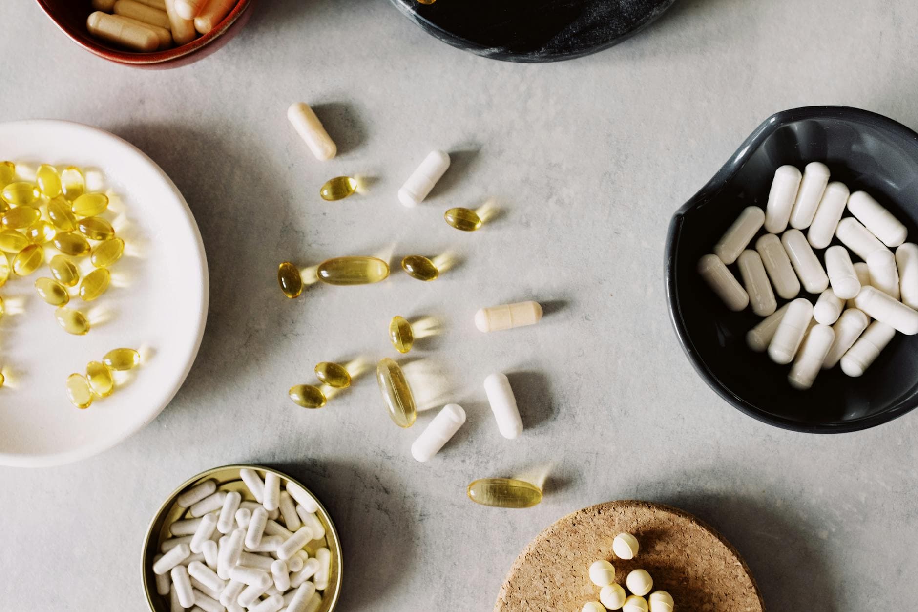 Assorted pills and capsules on marble, showcasing health supplements and treatments. - back pain medicine