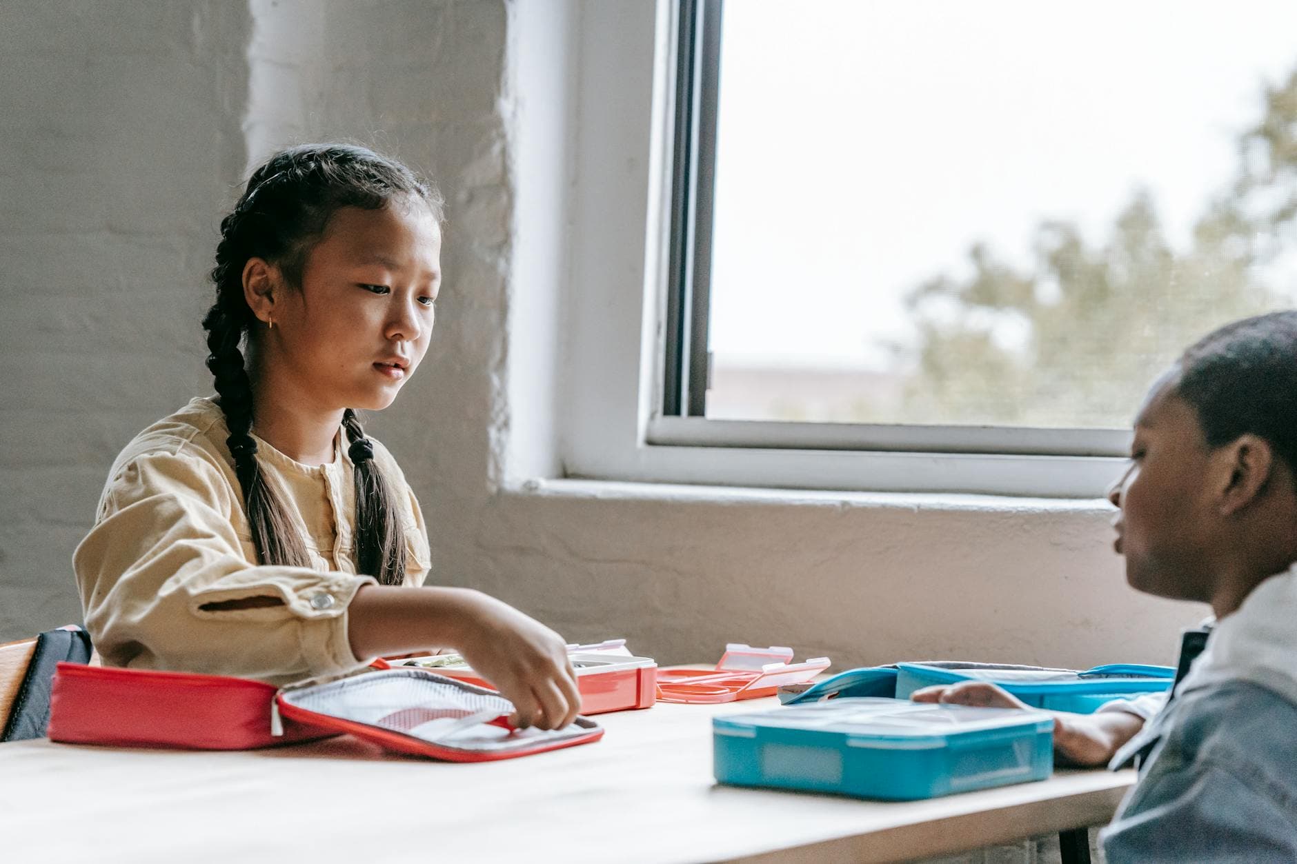 Multiethnic children enjoying lunch together in a well-lit classroom. - healthy school lunches