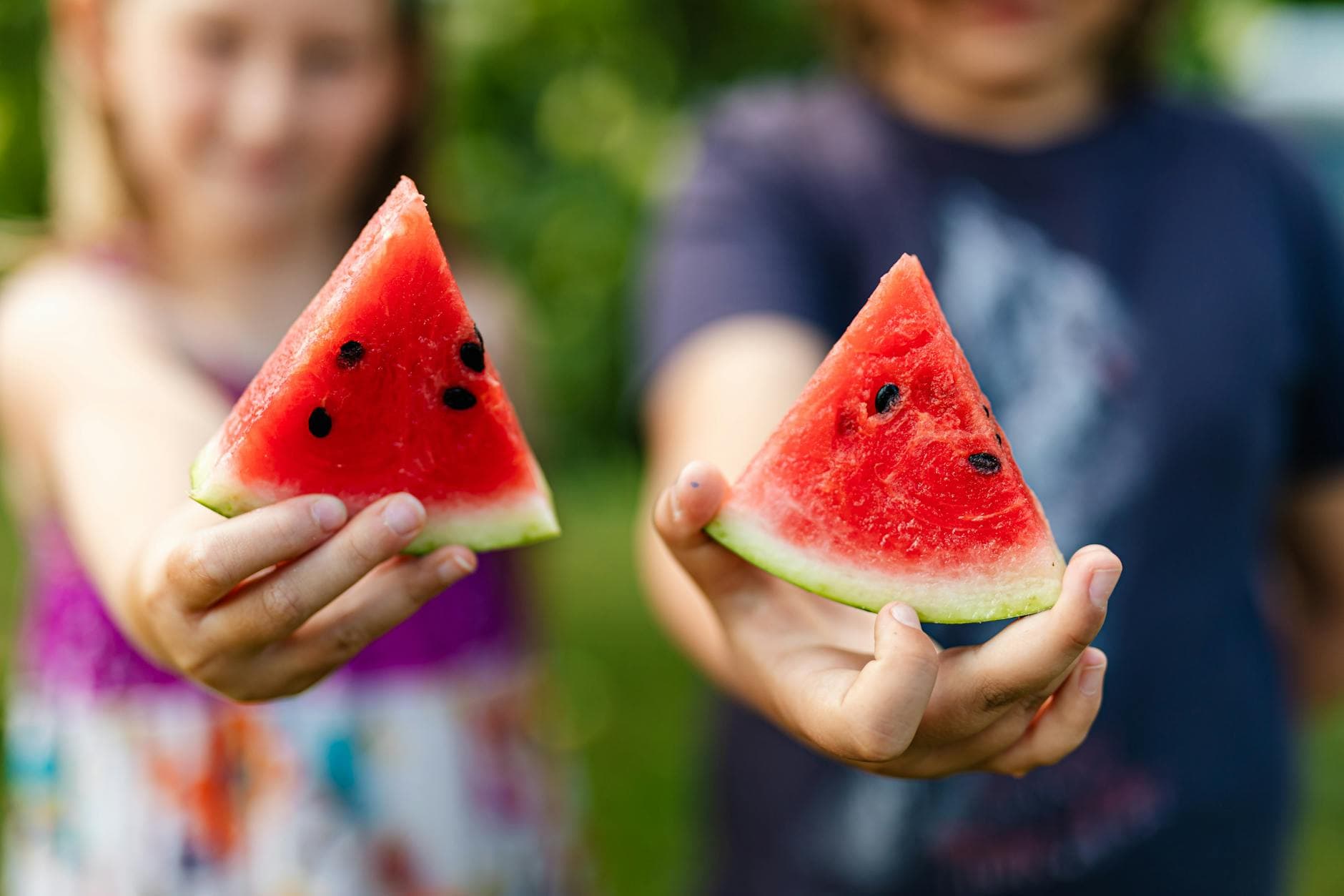 Close-up of children holding refreshing watermelon slices, symbolizing summer fun. - healthy snacks for kids