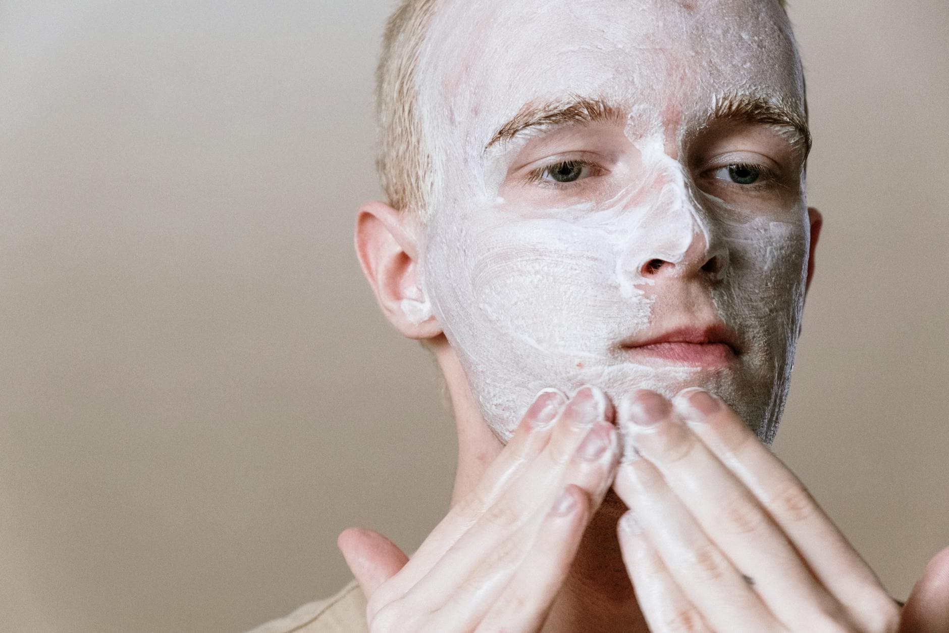 Close-up of a man applying facial cleanser for a refreshing skincare routine, focusing on self-care and health. - natural skincare routine steps