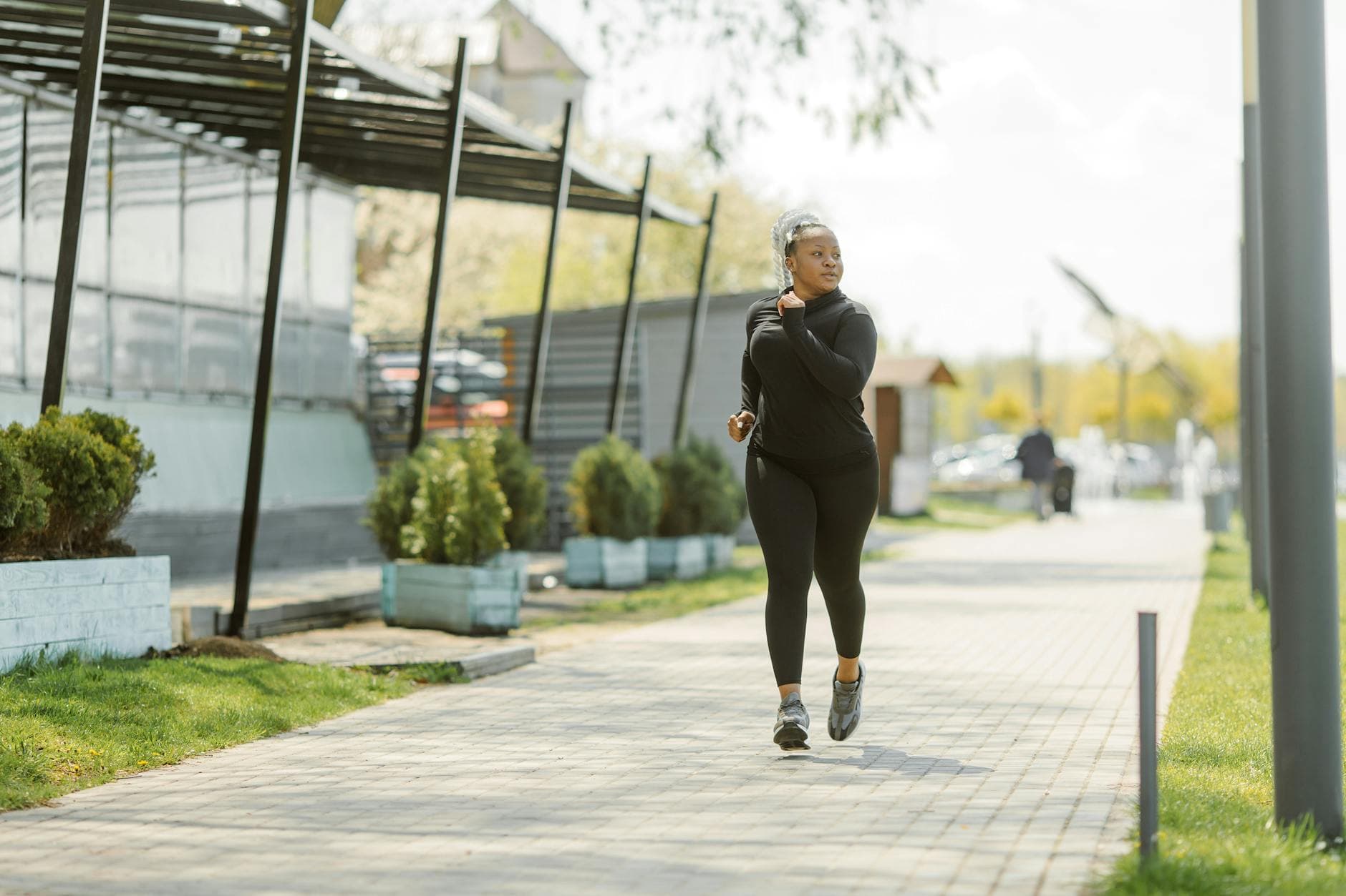 An African American woman jogging on a sunny day, embracing a healthy lifestyle. - spring exercise motivation