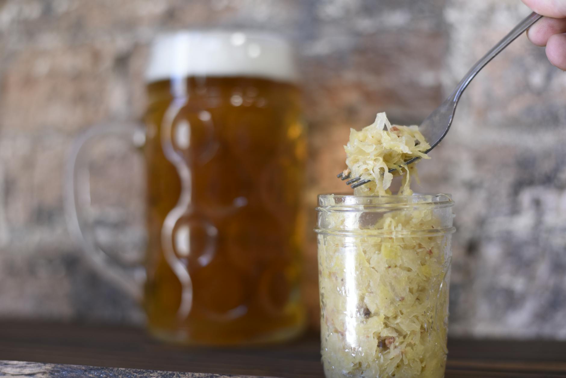 A rustic setting featuring a frothy beer mug and sauerkraut in a jar, perfect for pub themes. - best gut health foods