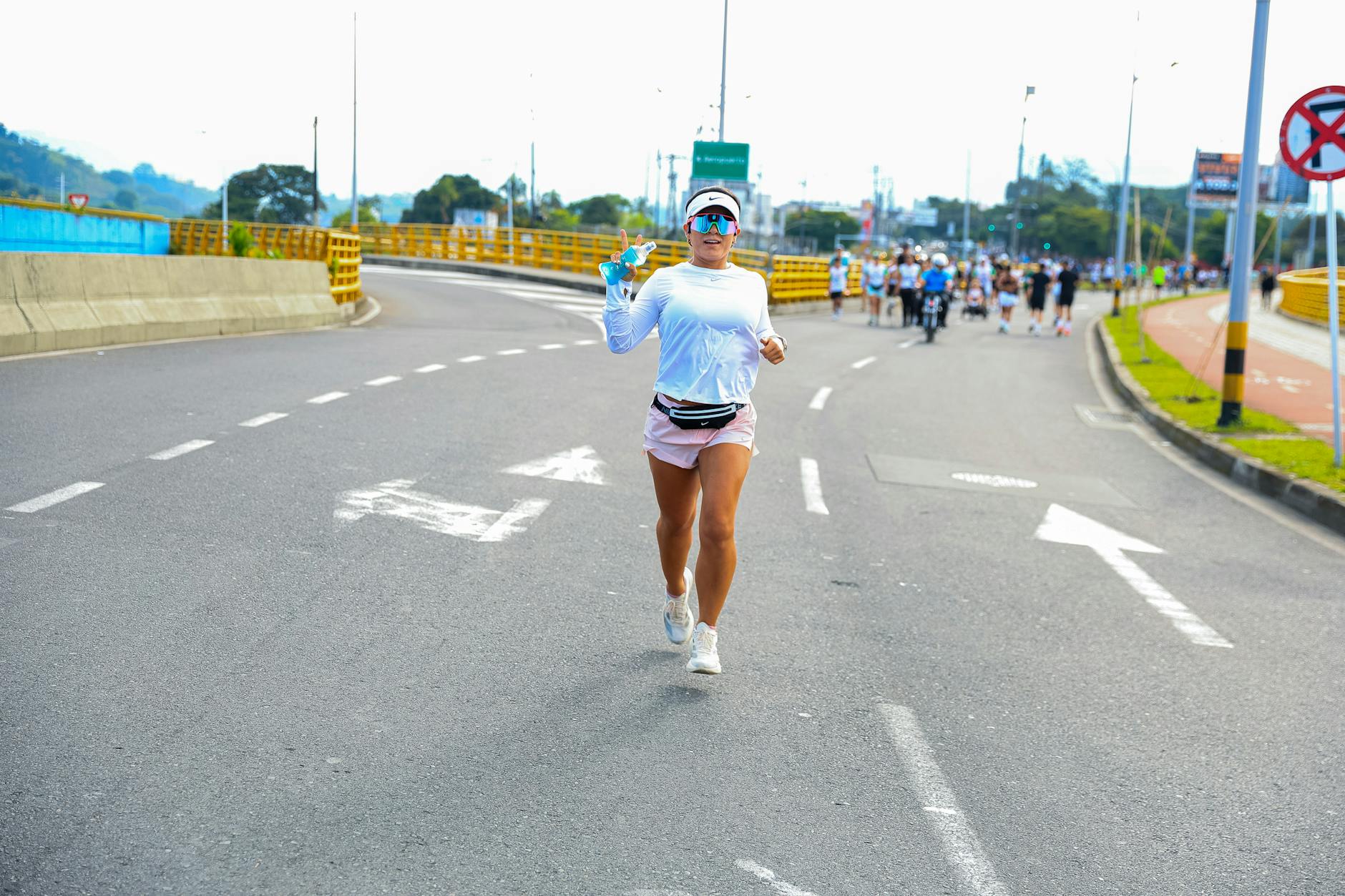 Athletic woman running on city road during marathon in bright daylight. - best morning exercises
