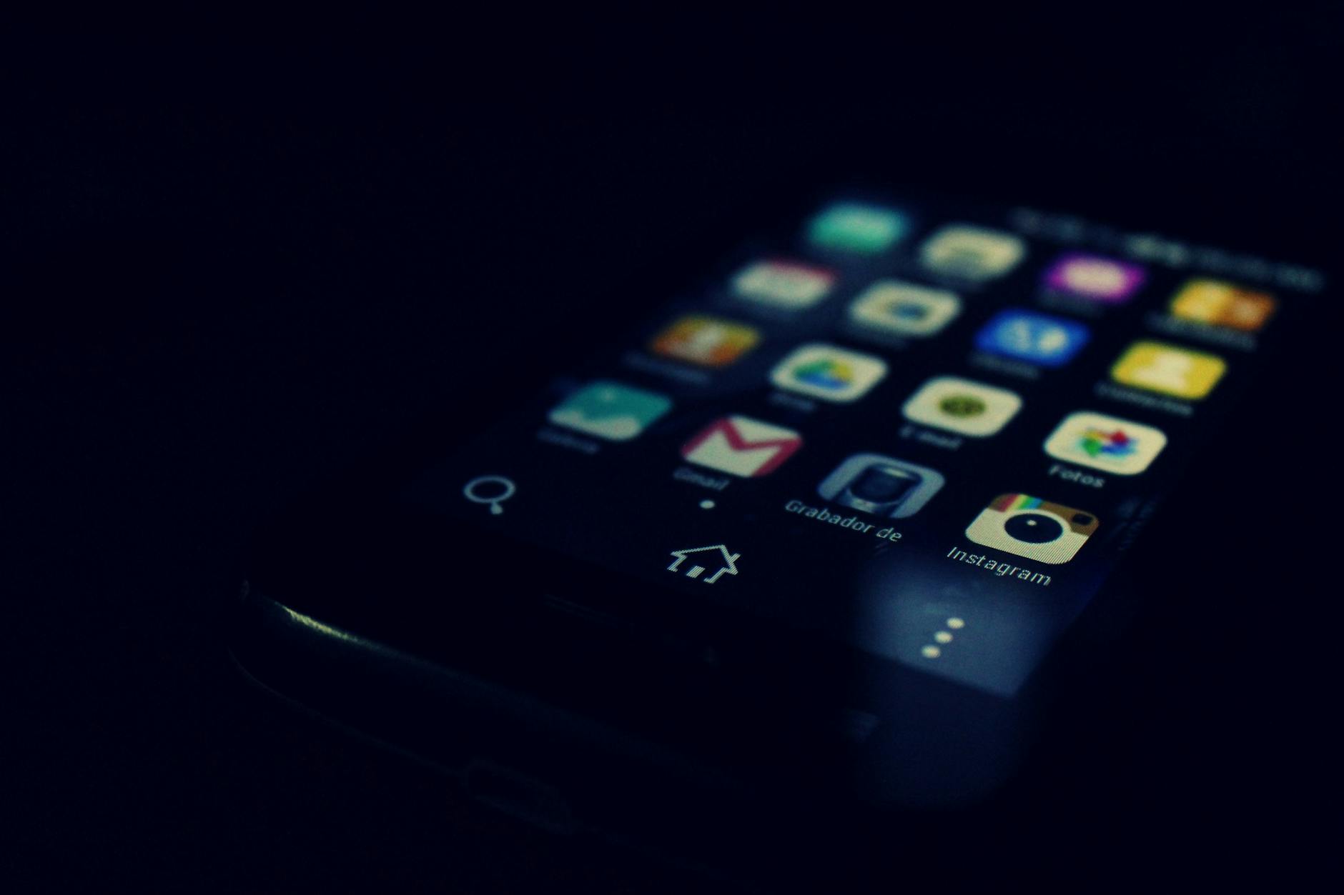 Dark-themed close-up of a smartphone screen highlighting various apps and touchscreen technology. - best walking app
