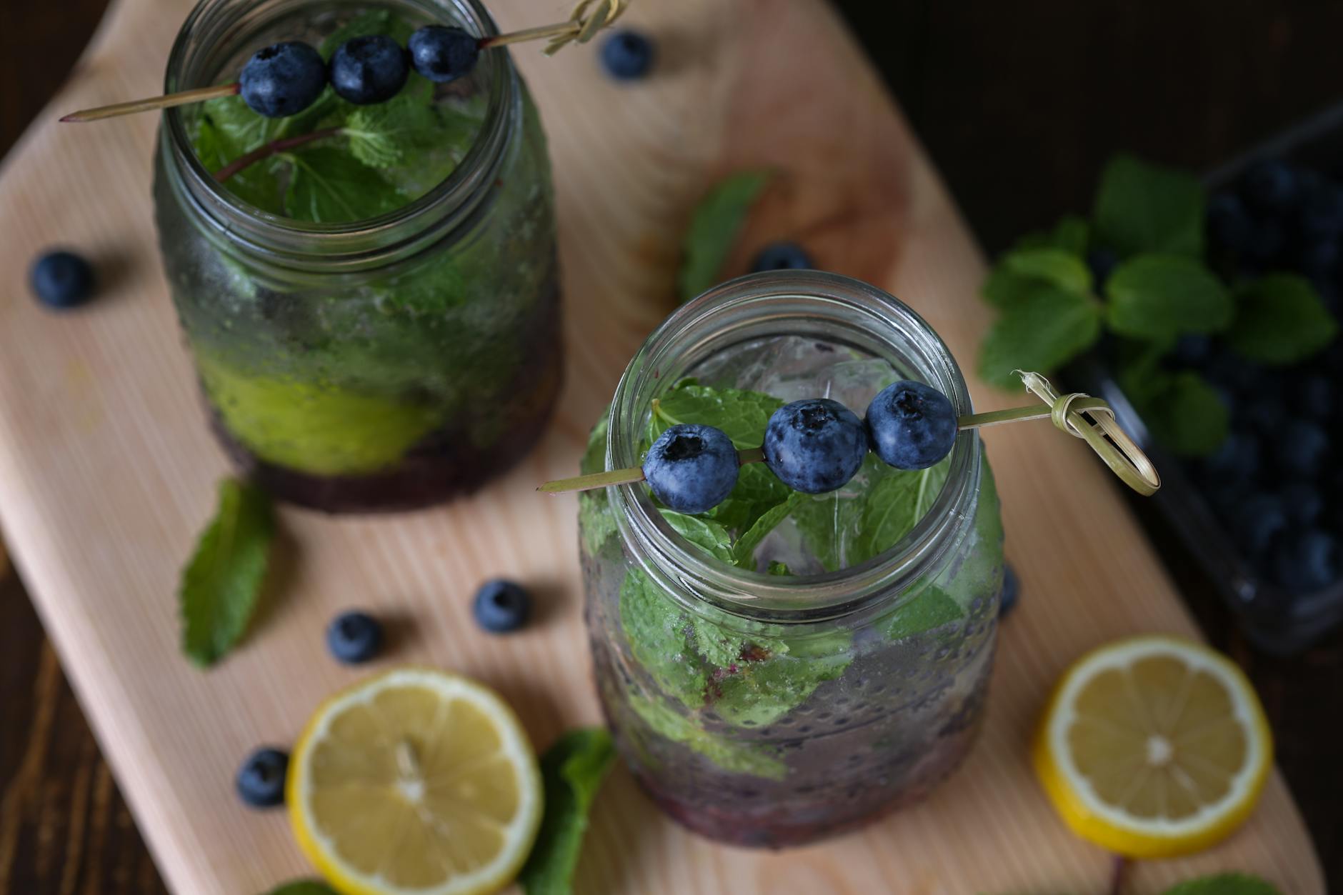 Top-down view of blueberry lemonade in jars with mint and lemon slices, perfect for a refreshing summer drink. - detox water recipes