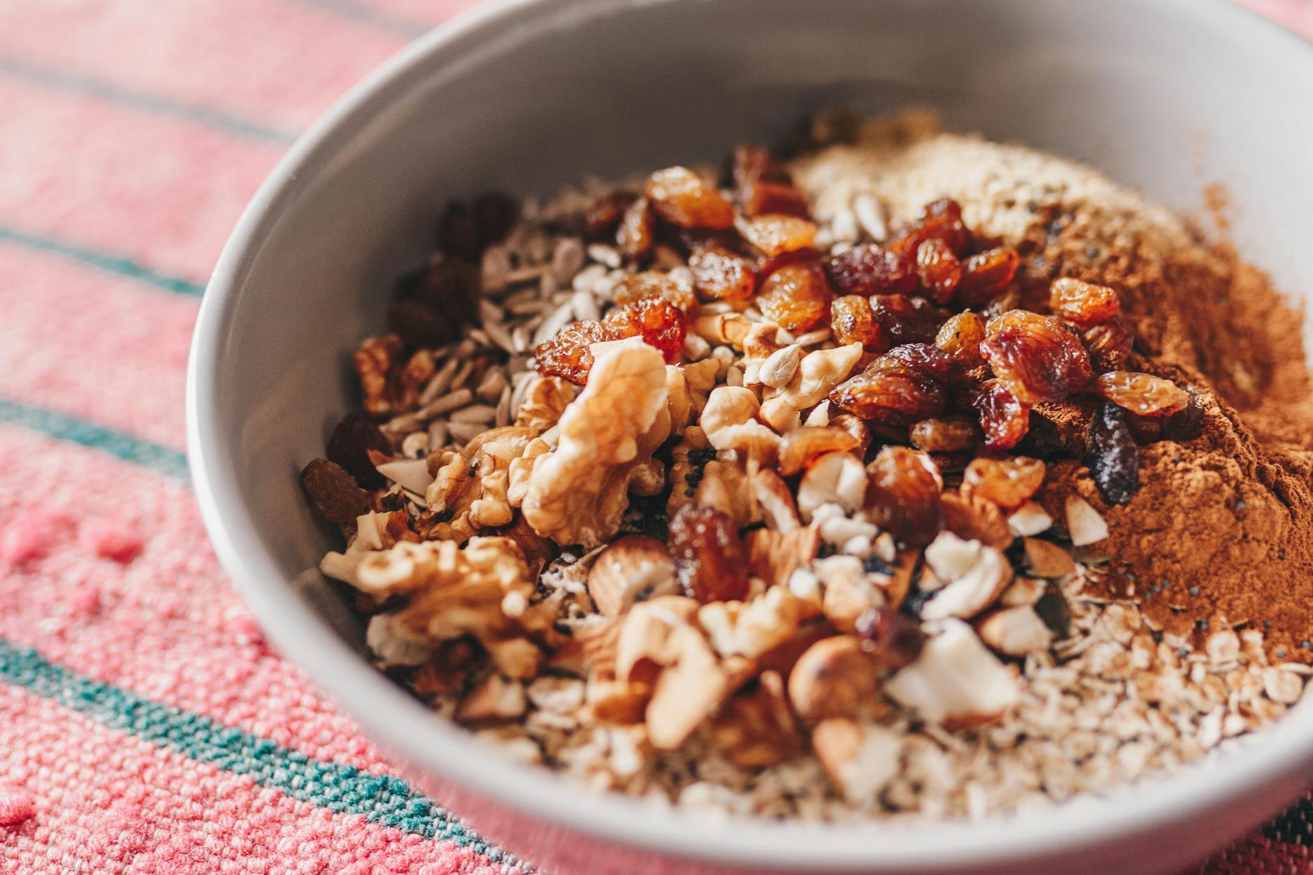 A nutritious oatmeal bowl topped with walnuts, sunflower seeds, and raisins. - energy boosting foods women