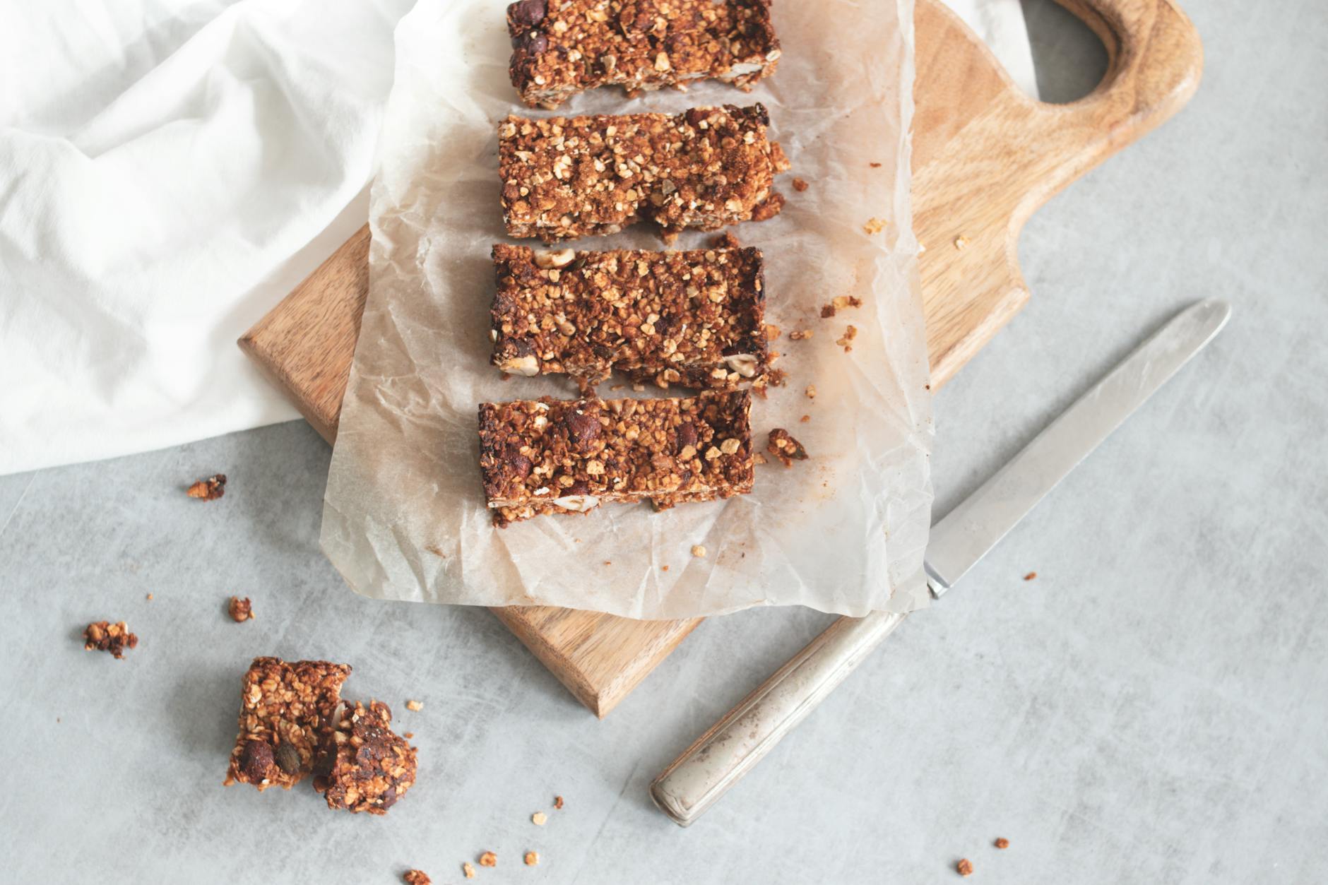 Delicious homemade granola bars on a wooden board, perfect for healthy snacking and meal preparation. - energy boosting foods women
