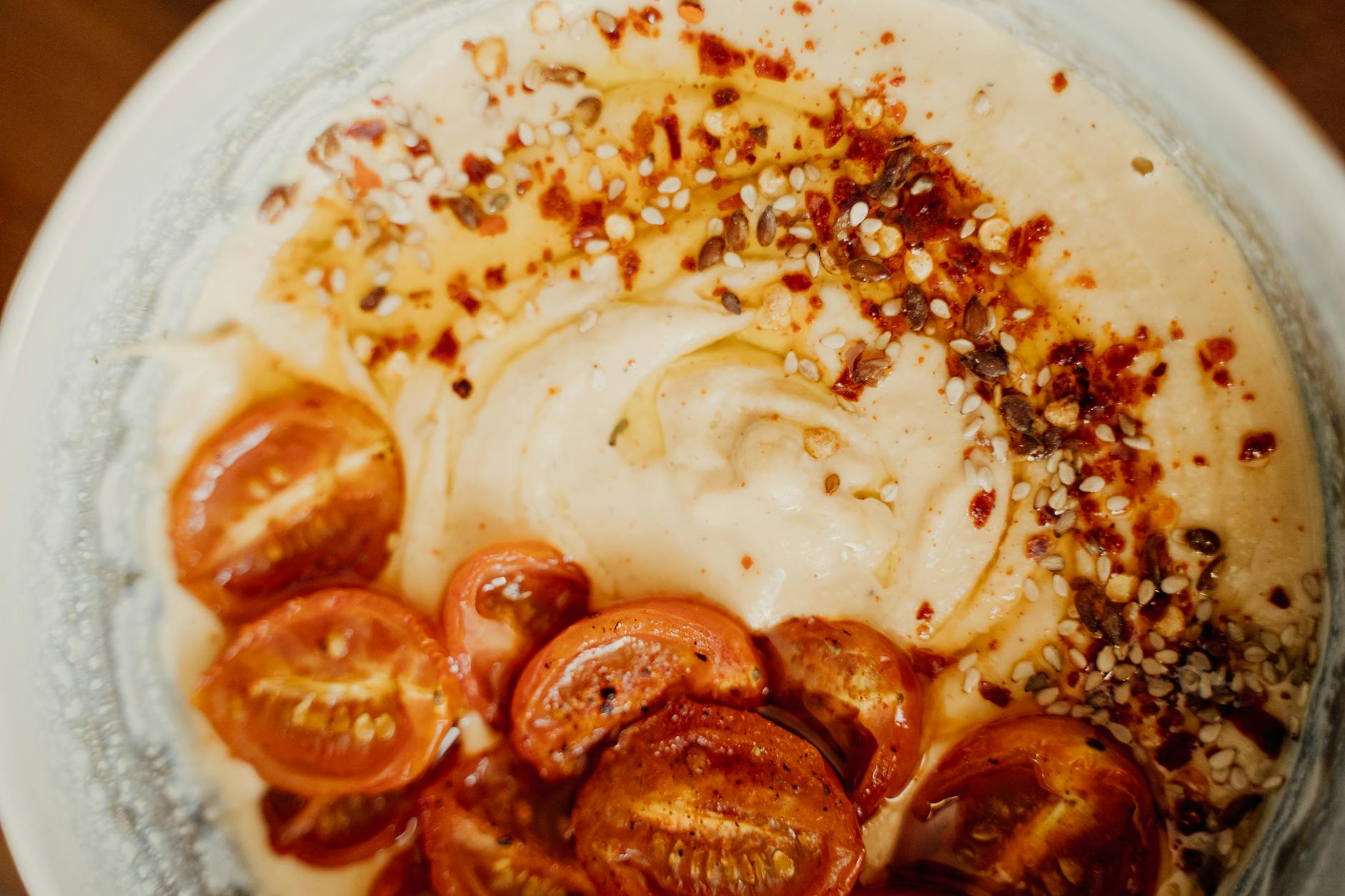 Delicious spiced hummus topped with roasted cherry tomatoes and sesame seeds. - healthy dinner recipes