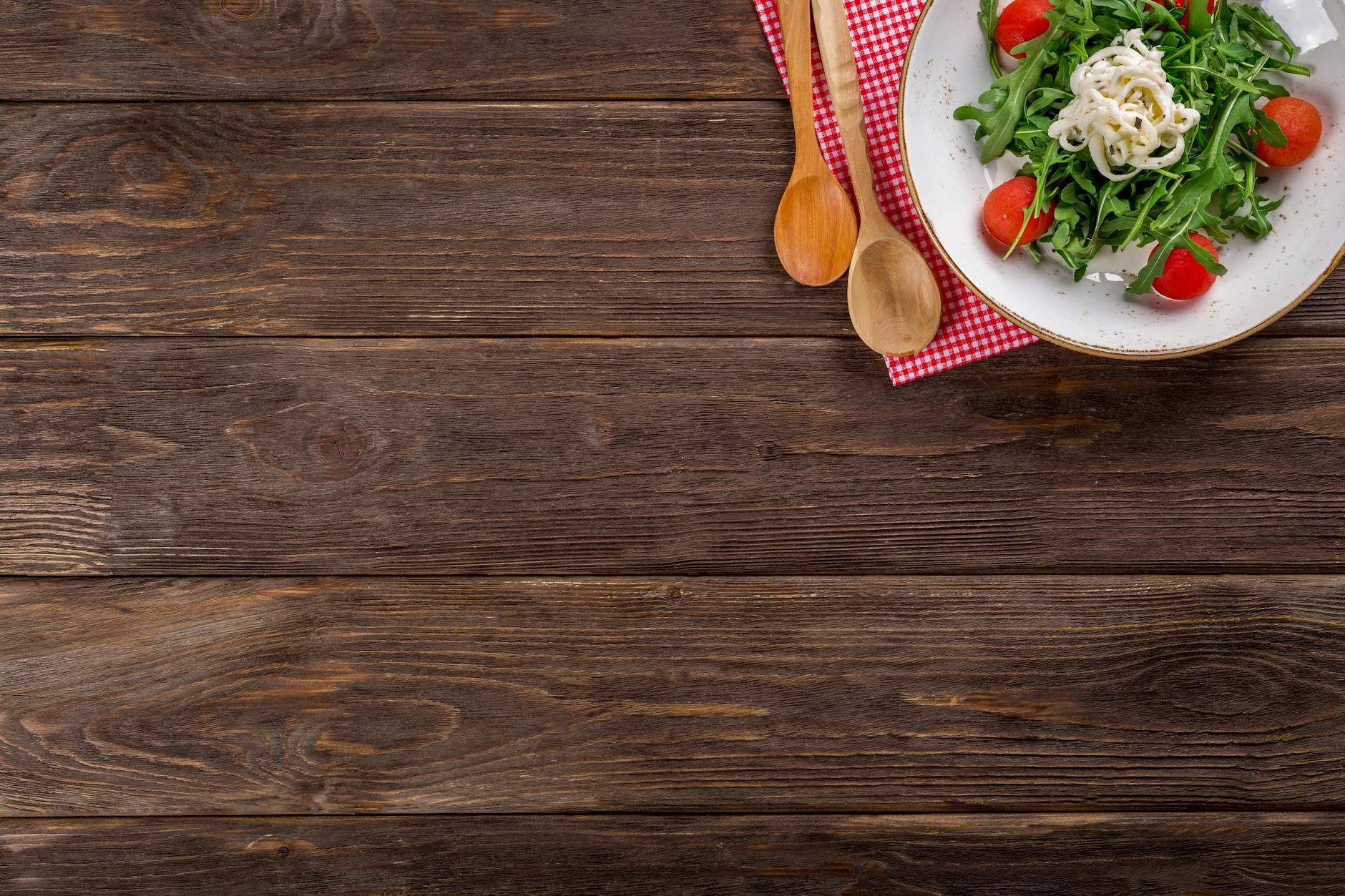 A delicious arugula salad with cherry tomatoes and pasta served on a rustic wooden table with space for text. - healthy dinners for two