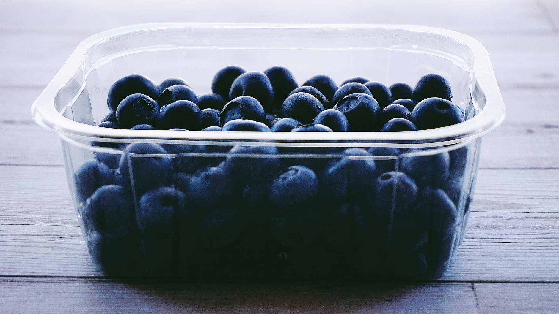 Delicious fresh blueberries packed in a transparent plastic container, perfect for a healthy snack. - healthy snacks to buy