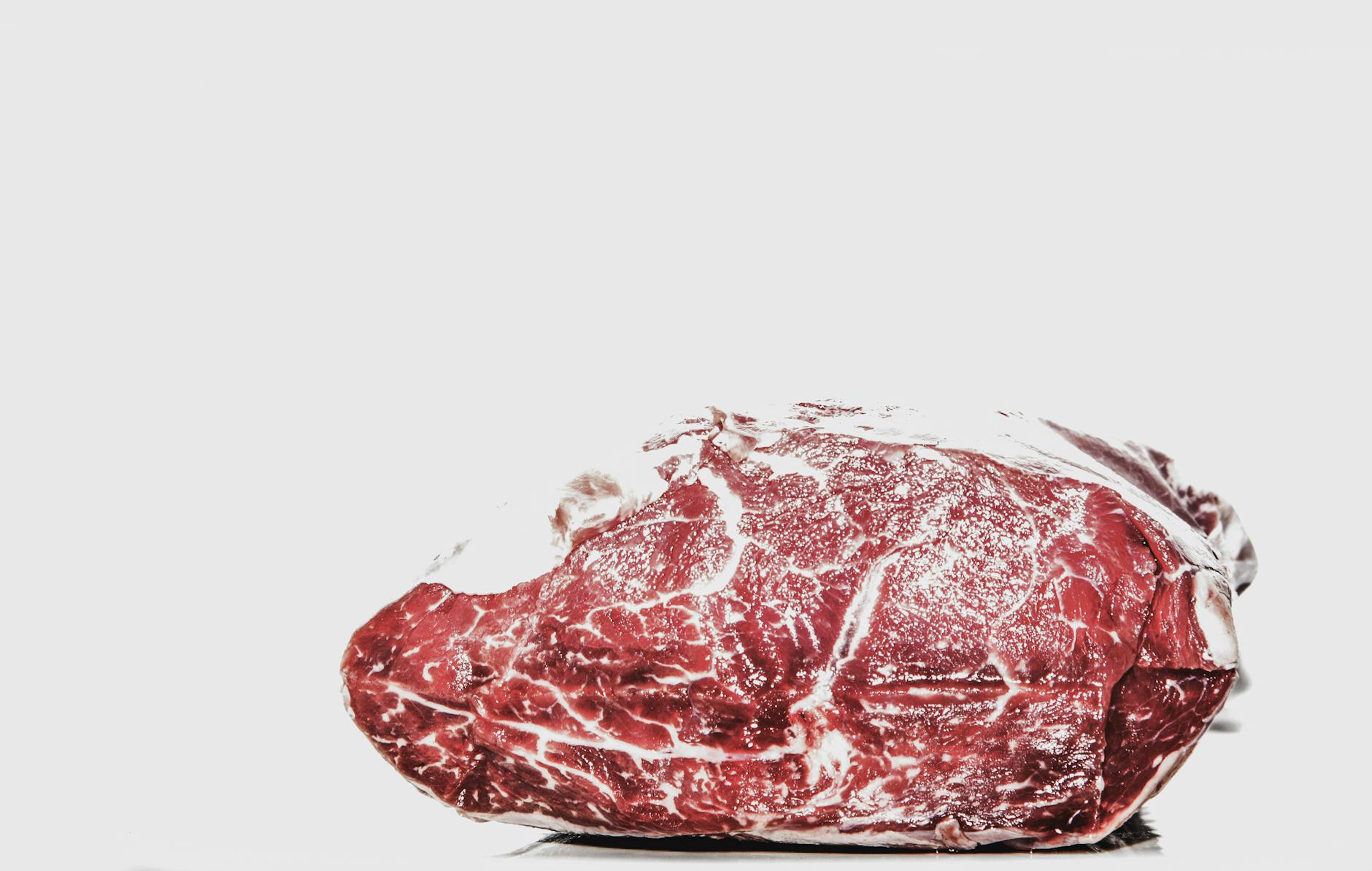 Premium raw beef piece displayed on a white background, perfect for culinary projects. - high protein foods