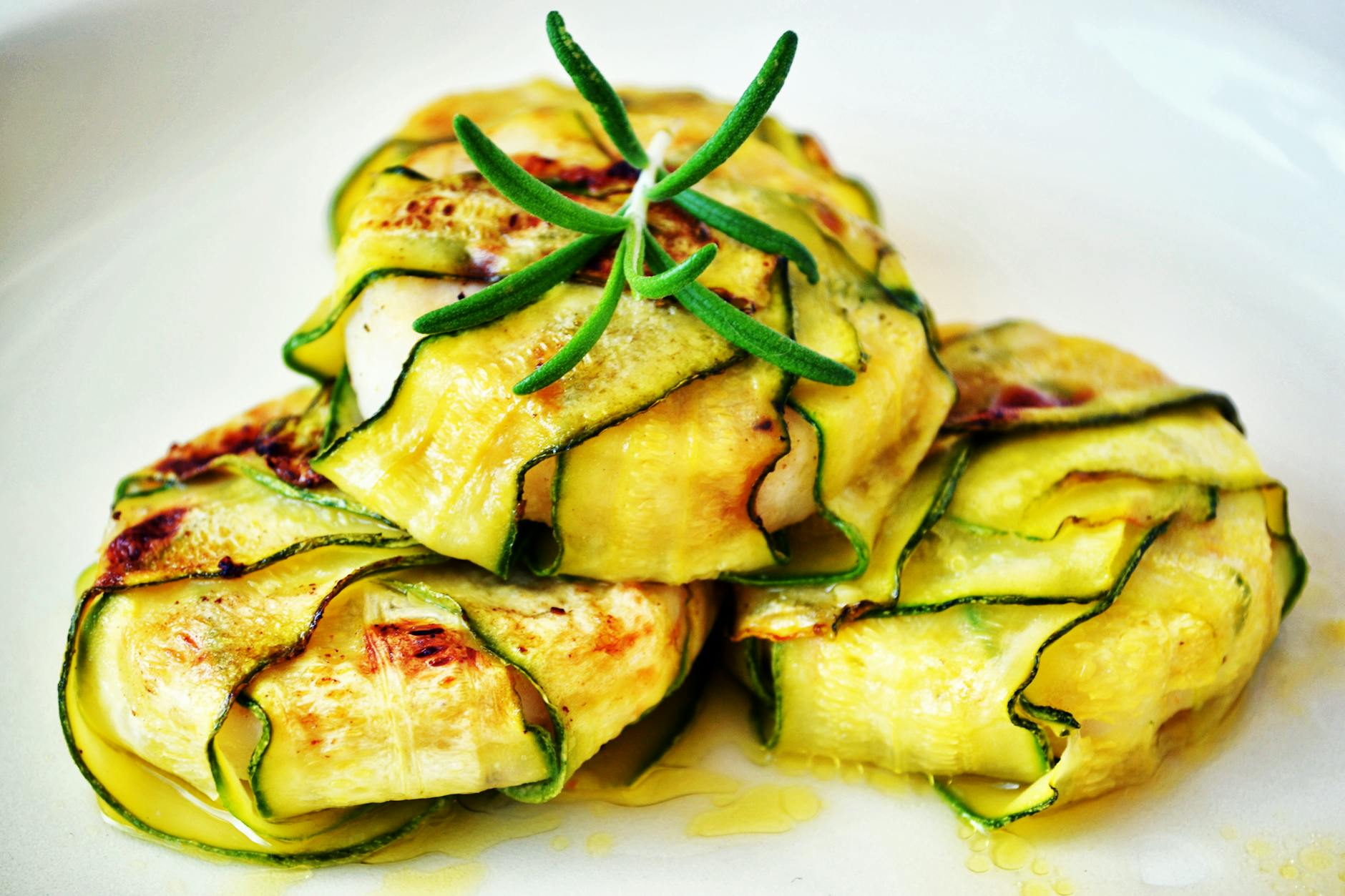 Delicious zucchini wraps stuffed with grilled chicken, presented with fresh rosemary garnish. - low calorie deficit