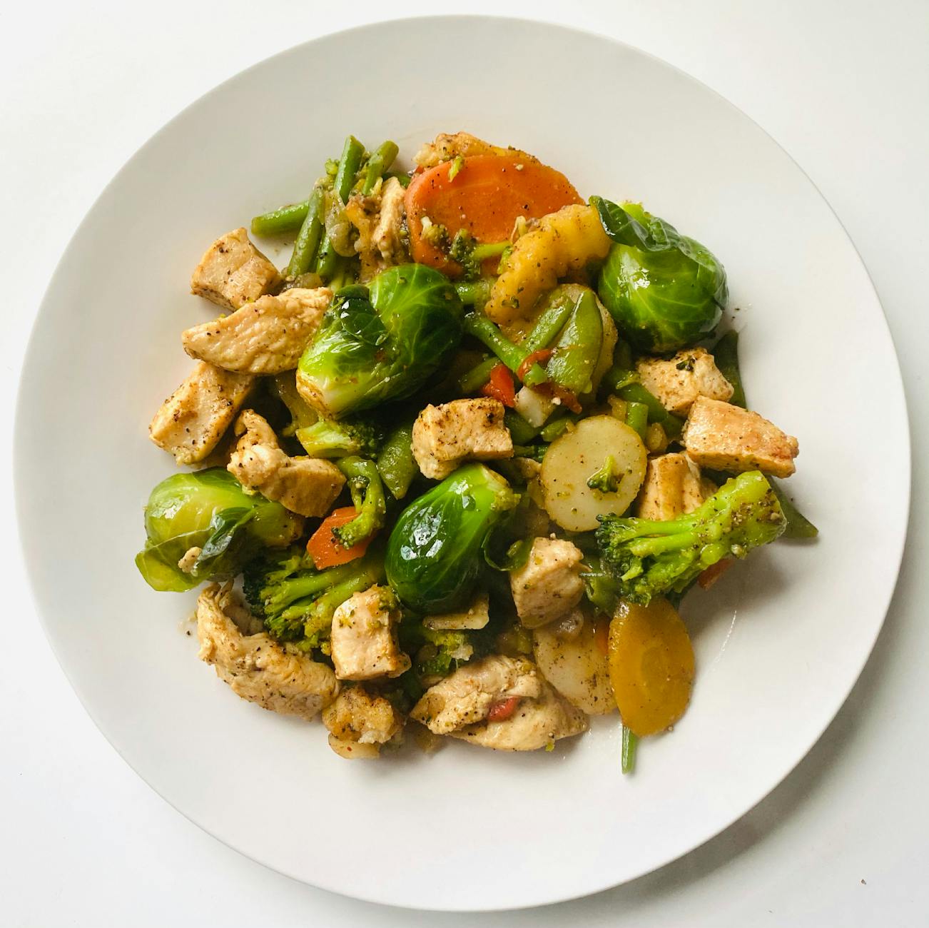 Delicious stir-fry of chicken and vegetables on a white plate for a healthy meal. - low carb dinner recipes
