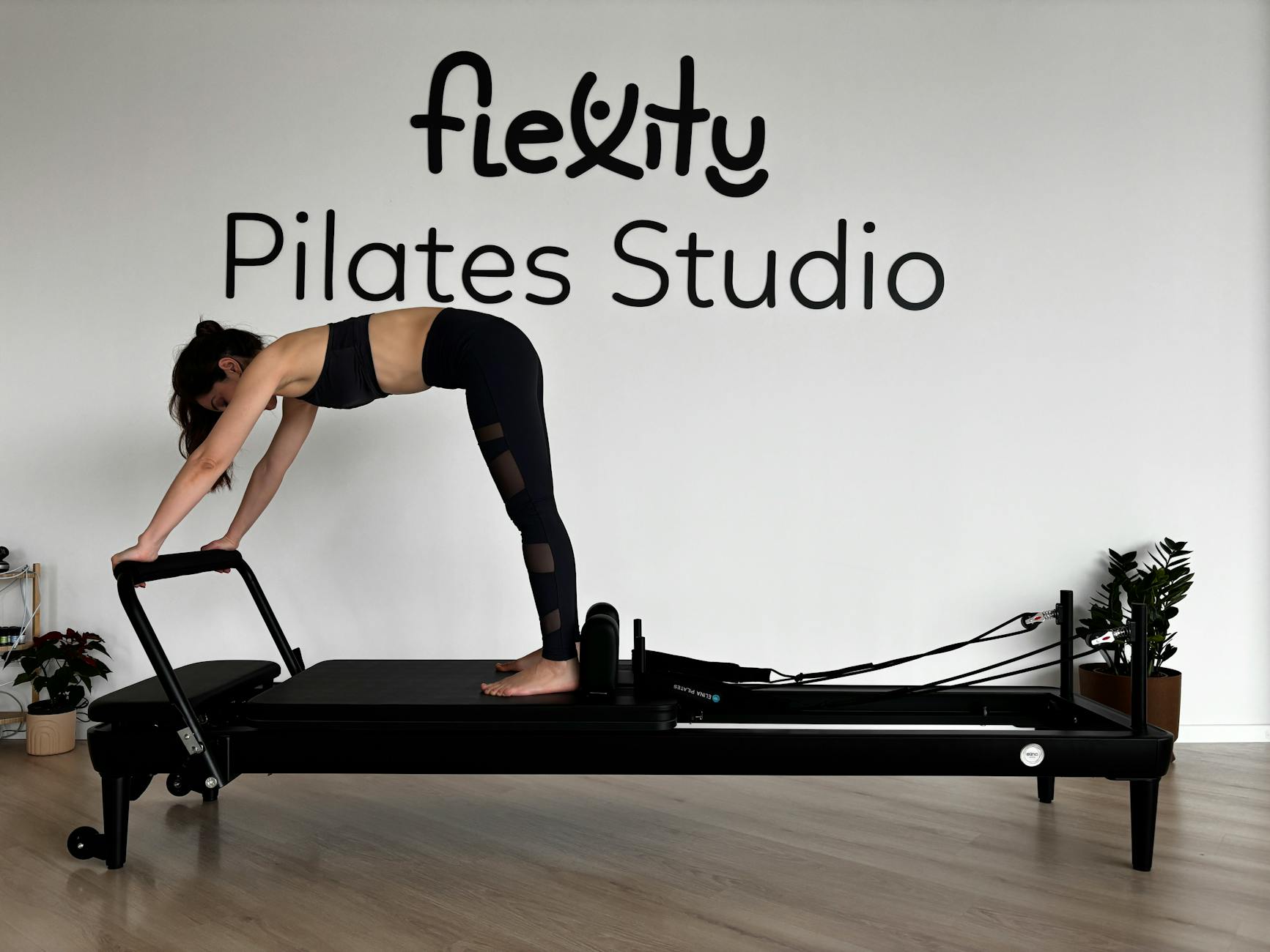 Woman performing Pilates on reformer machine in minimalist studio. - pilates workouts youtube