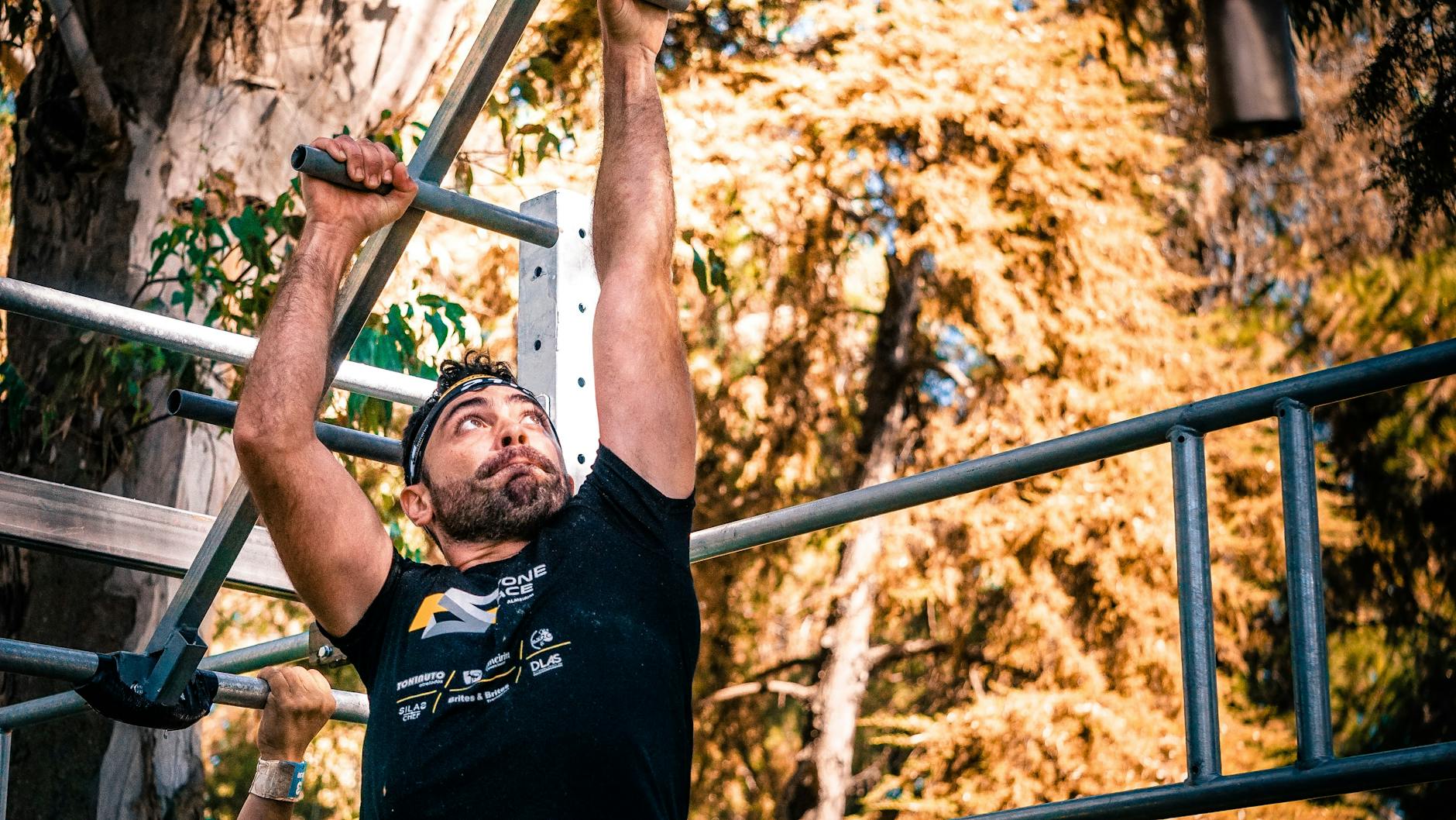 Man exercising on outdoor monkey bars, showcasing strength and fitness. - 30 day fitness challenge
