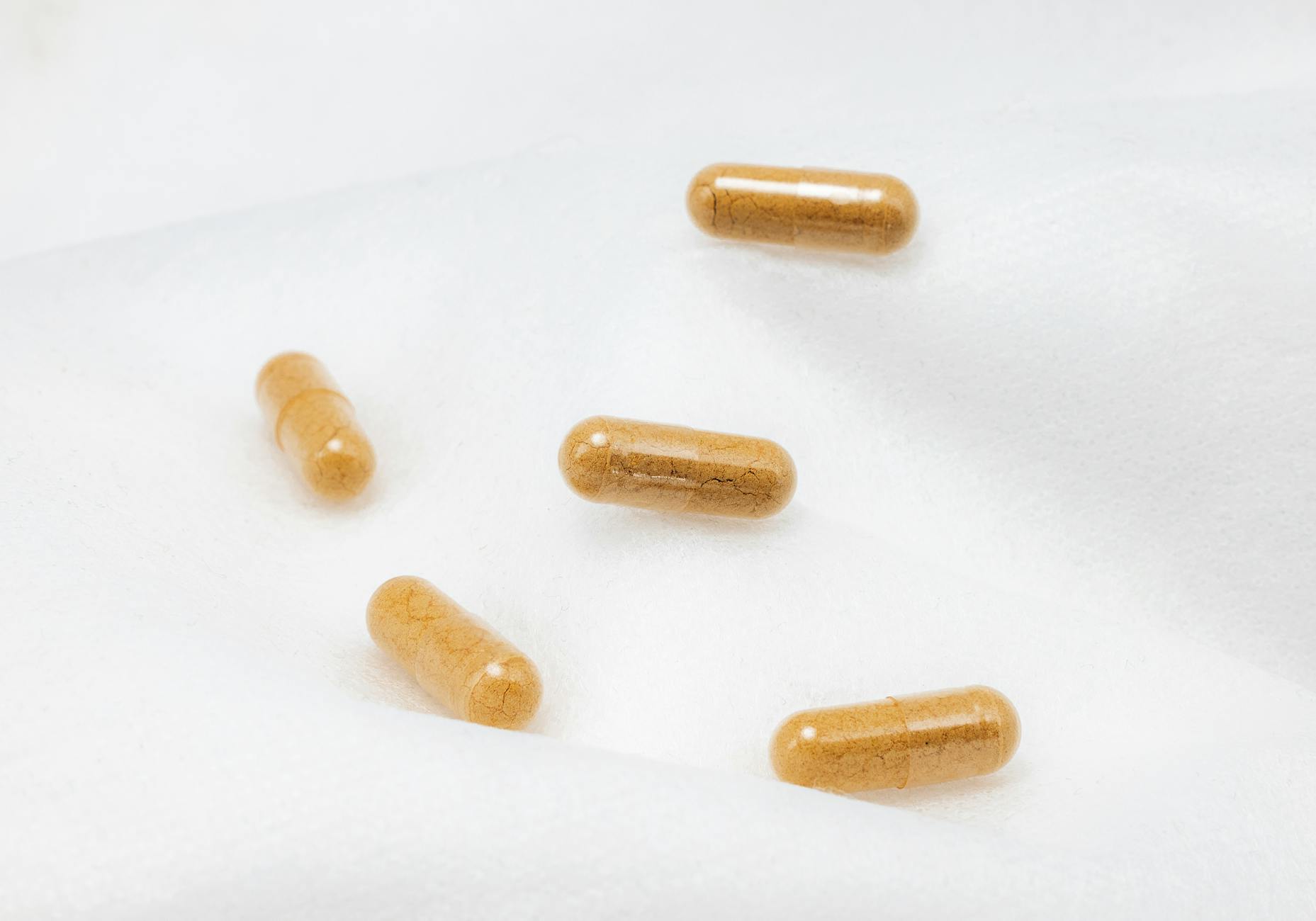Close-up of brown capsules on a white surface, emphasizing health and supplements. - best magnesium supplement