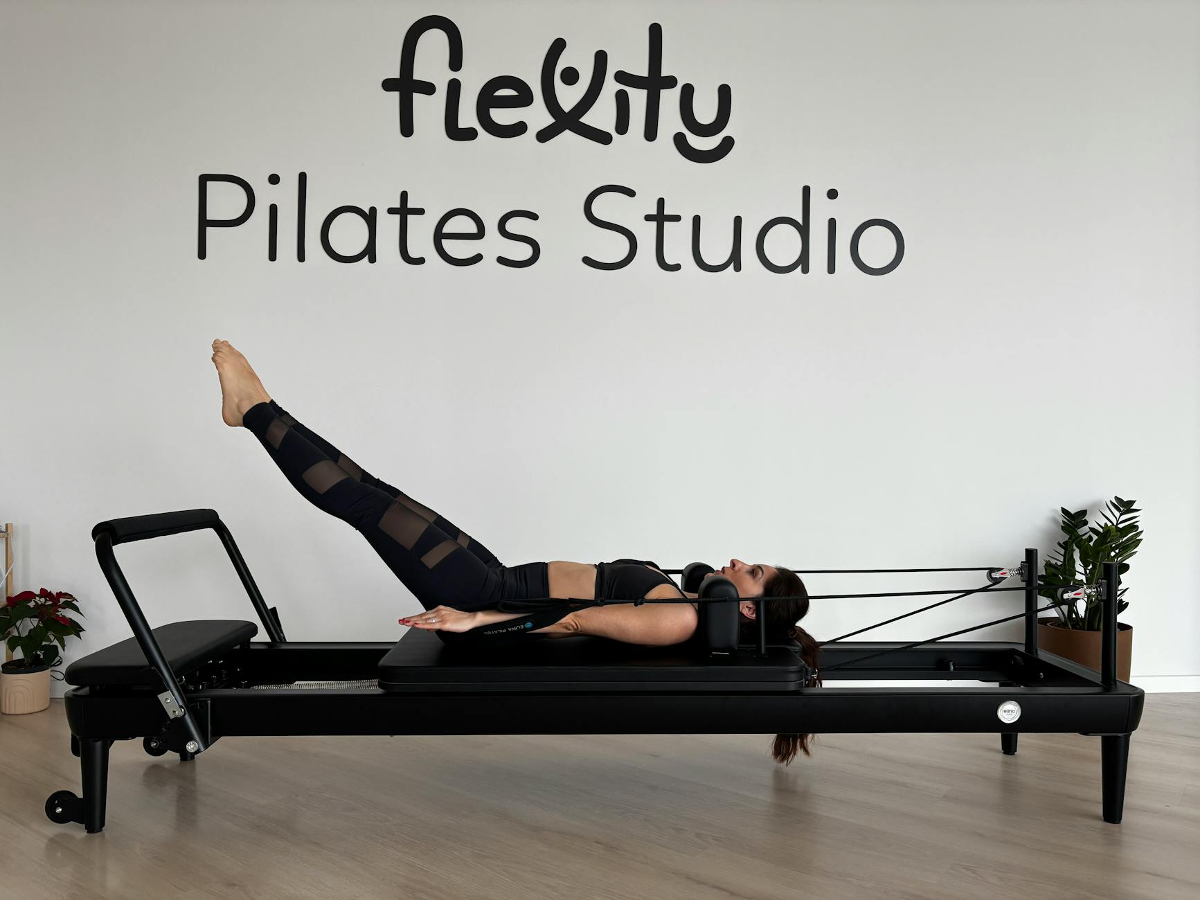 A woman performing Pilates exercises on a reformer in a modern fitness studio. - best pilates exercises