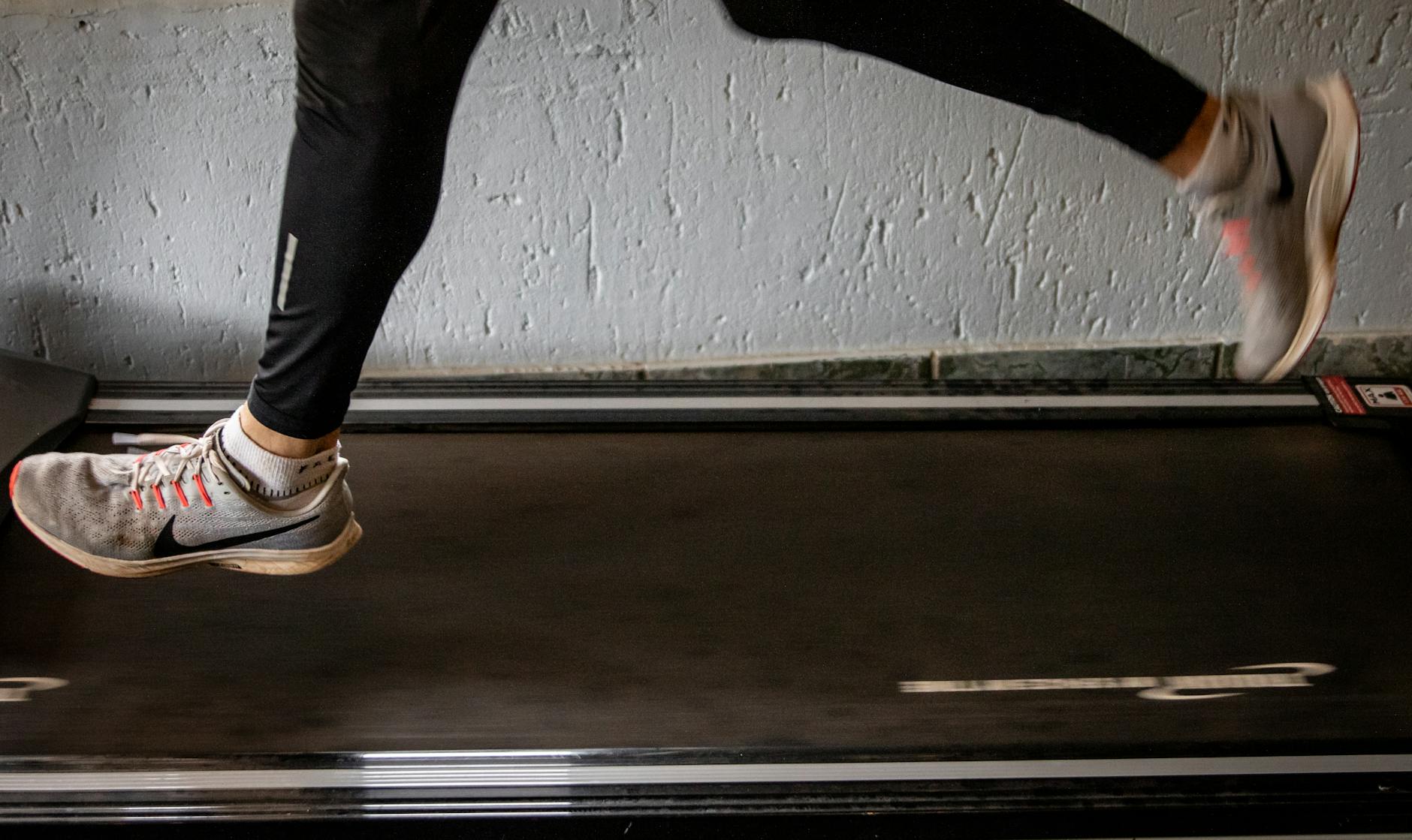 Close-up of a woman's legs running on a treadmill indoors, focusing on fitness and exercise. - best treadmill for home