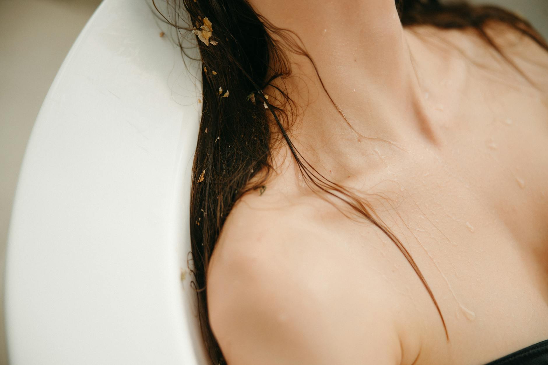 Close-up of a woman relaxing with wet hair, emphasizing skincare and wellness. - body detox cleanse