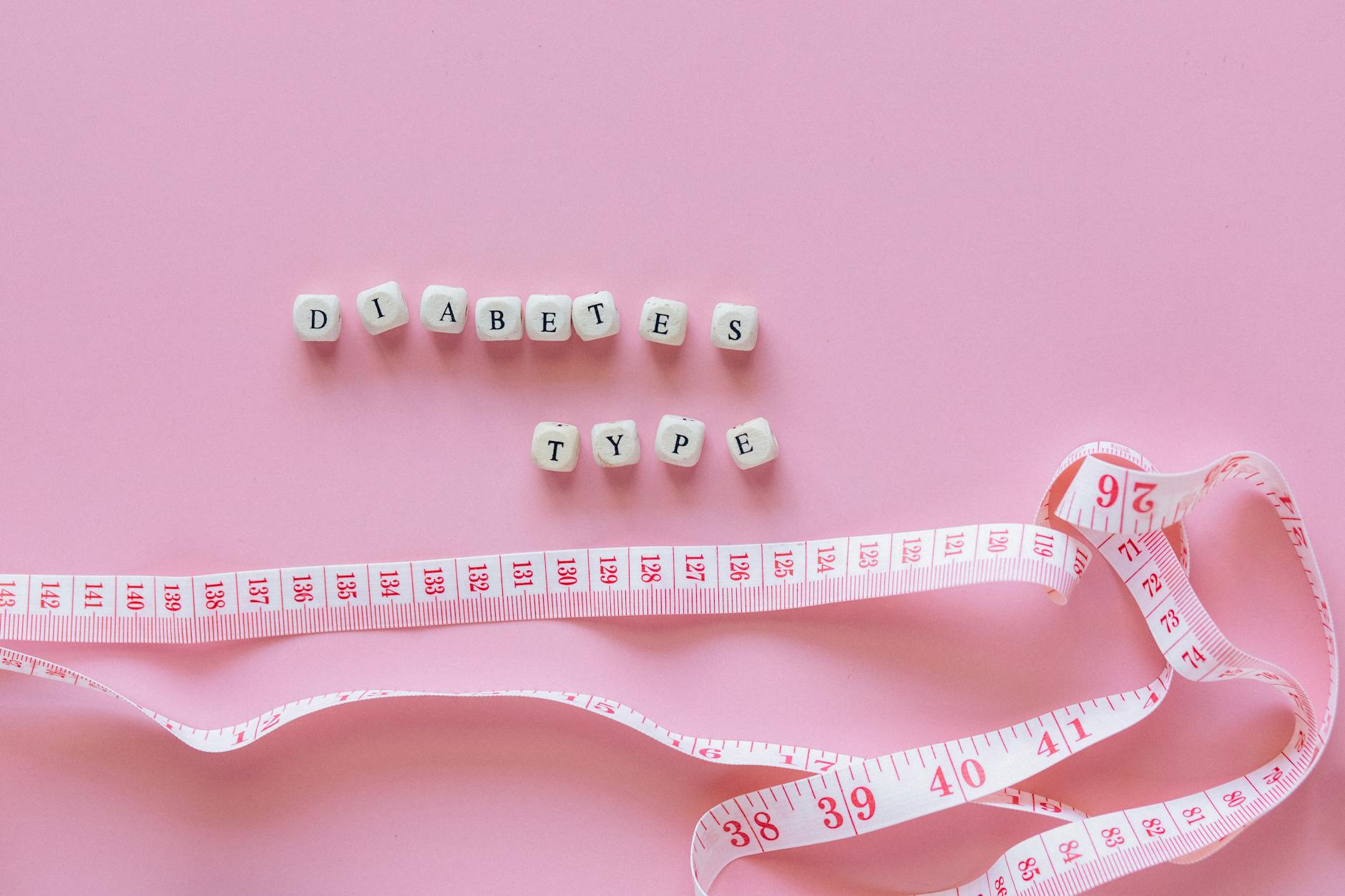 Close-up of diabetes type block letters and measuring tape on pink background. - boost metabolism spring