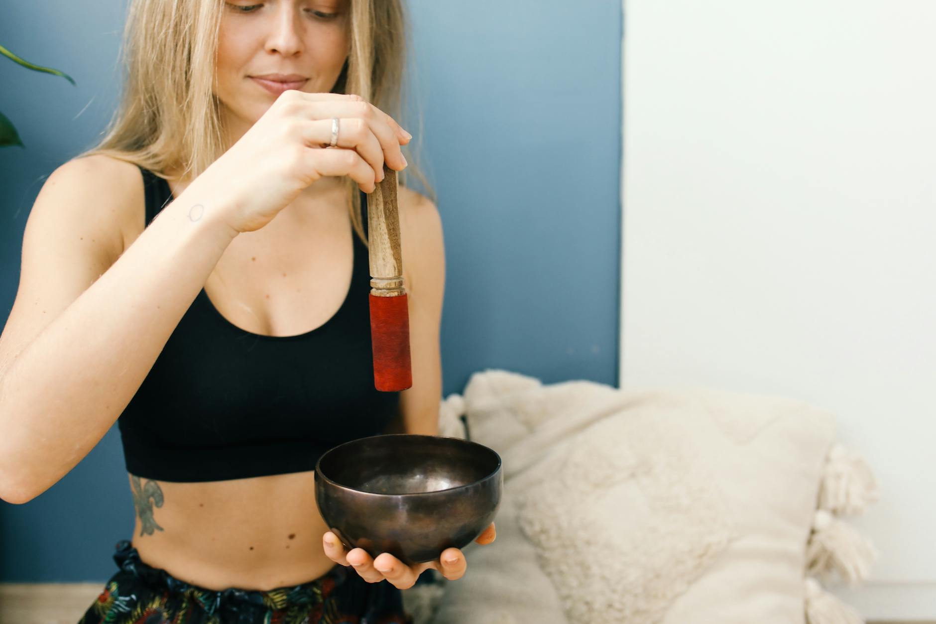 Young woman using a singing bowl for meditation. Relaxing indoor setting with a peaceful ambiance. - boost metabolism spring