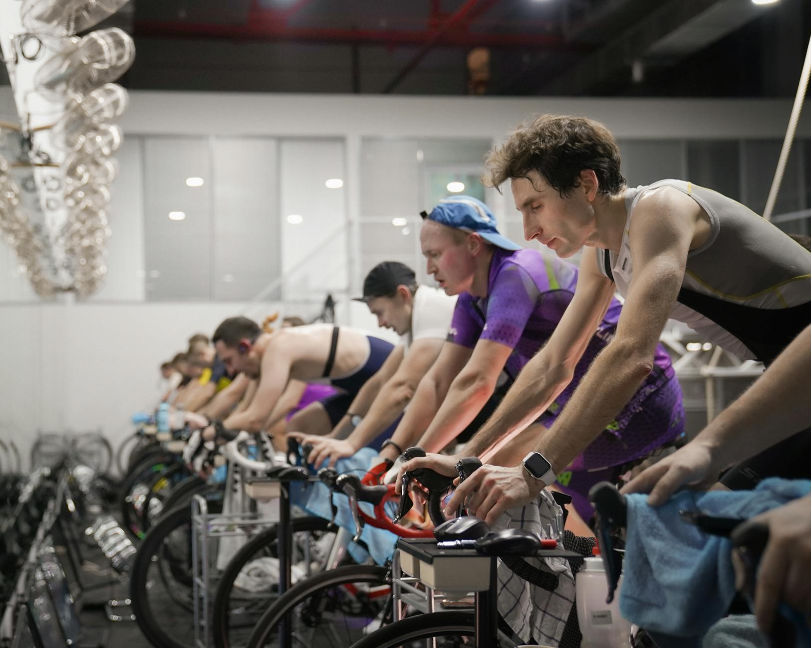 Athletes engaged in a high-intensity indoor cycling session, enhancing fitness and endurance. - carb cycling workout