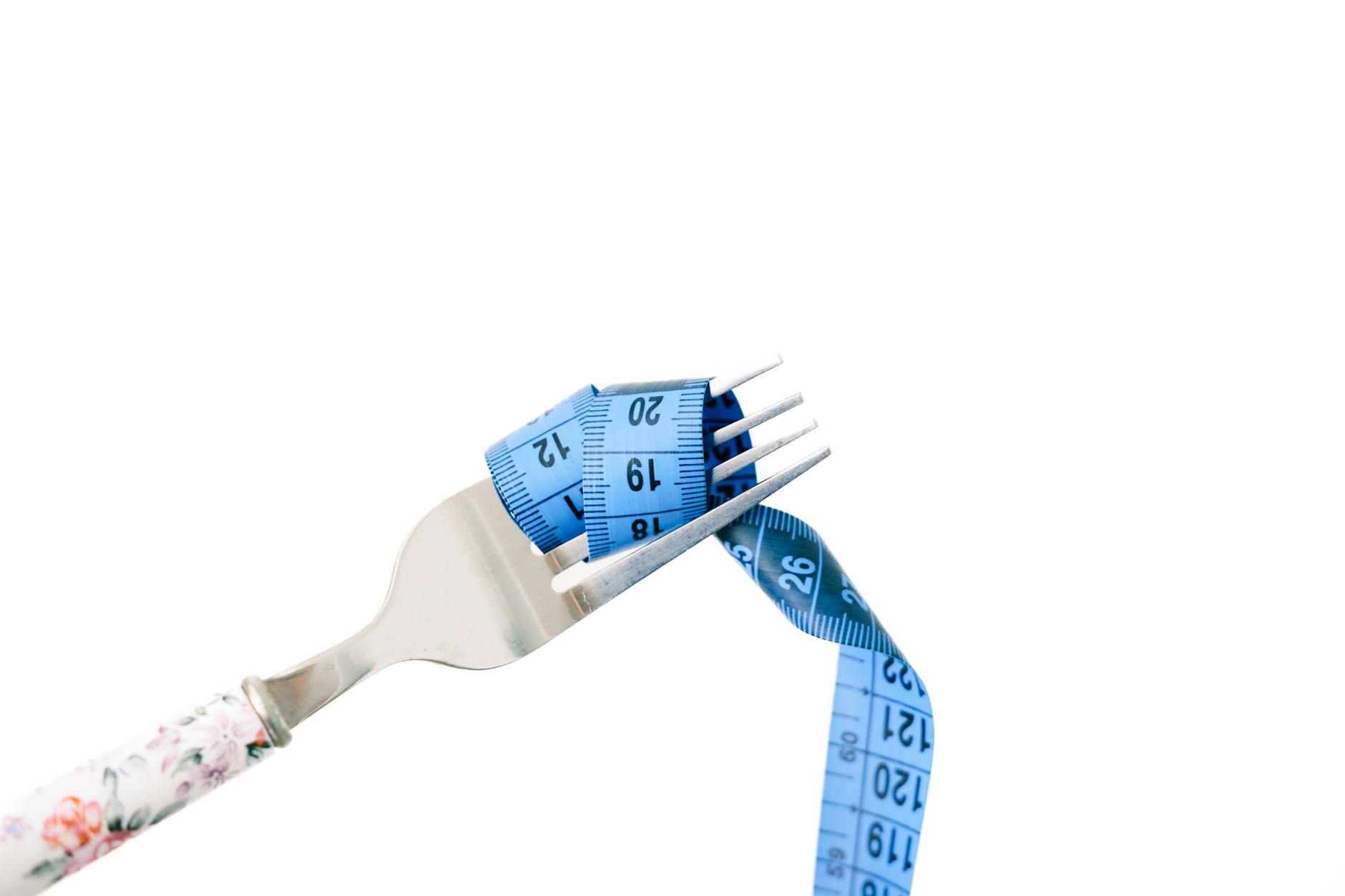 A fork entwined with a blue measuring tape, symbolizing dieting and weight management. - dash diet plan